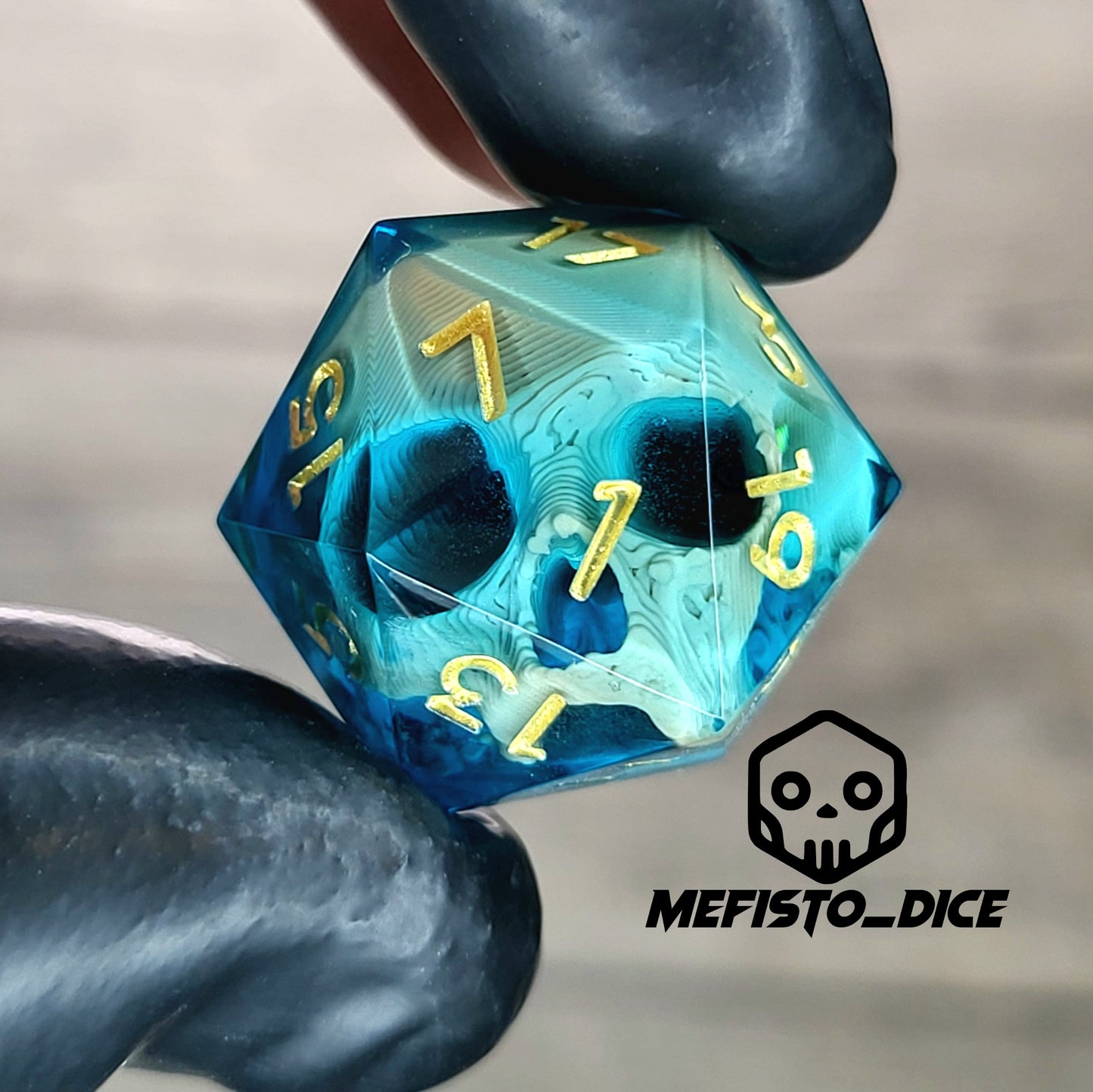 This is a single set of one D20 DnD die with a light brown skull inside , blue resin and gold numbers