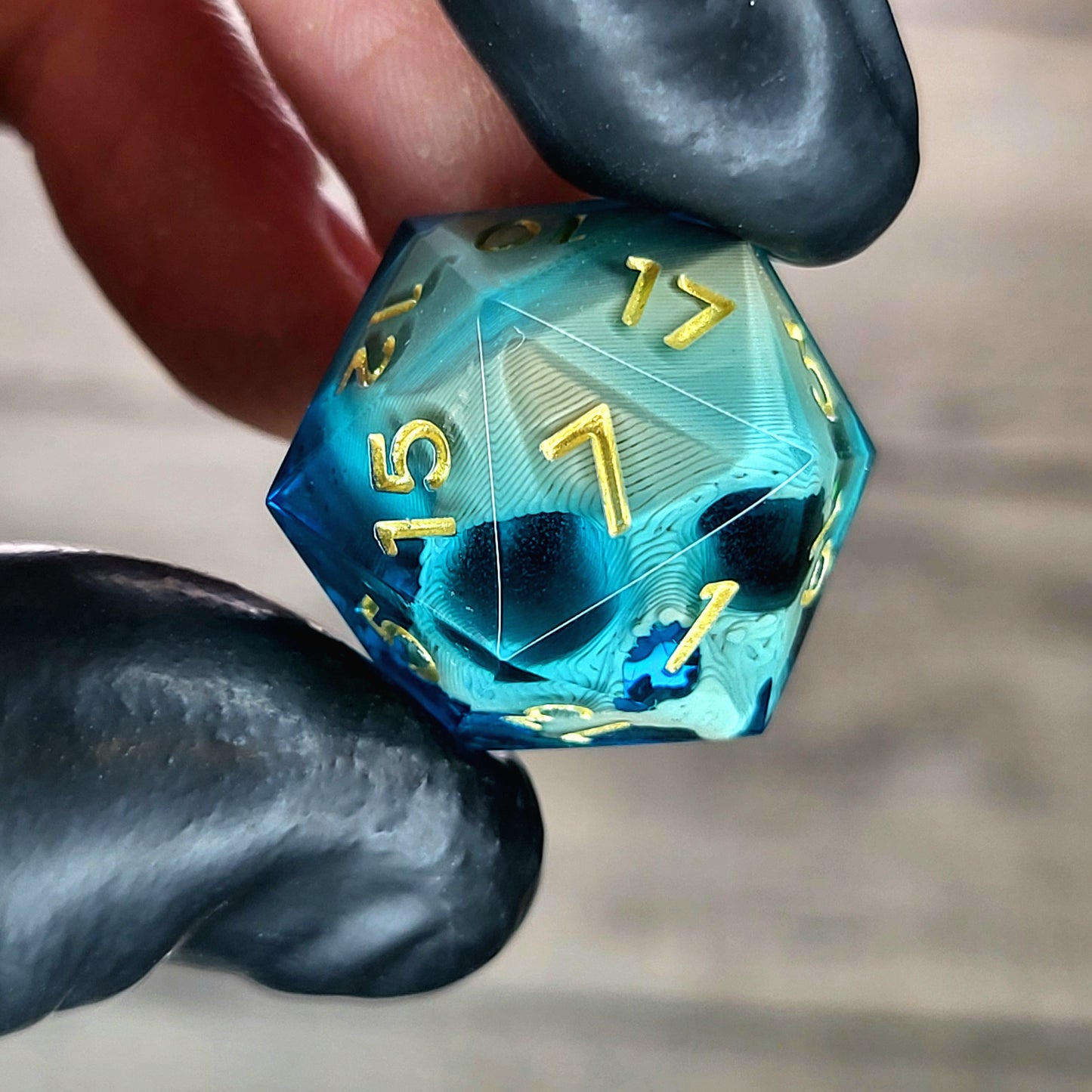 This is a single set of one D20 DnD die with a light brown skull inside , blue resin and gold numbers