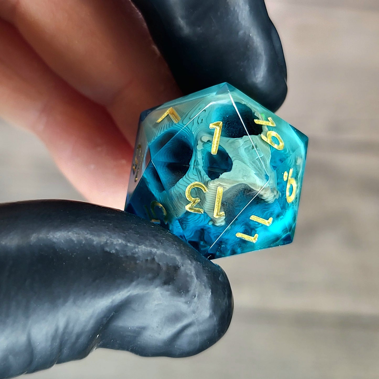 This is a single set of one D20 die with a light brown skull inside , blue resin and gold numbers for play dnd dungeons and dragons