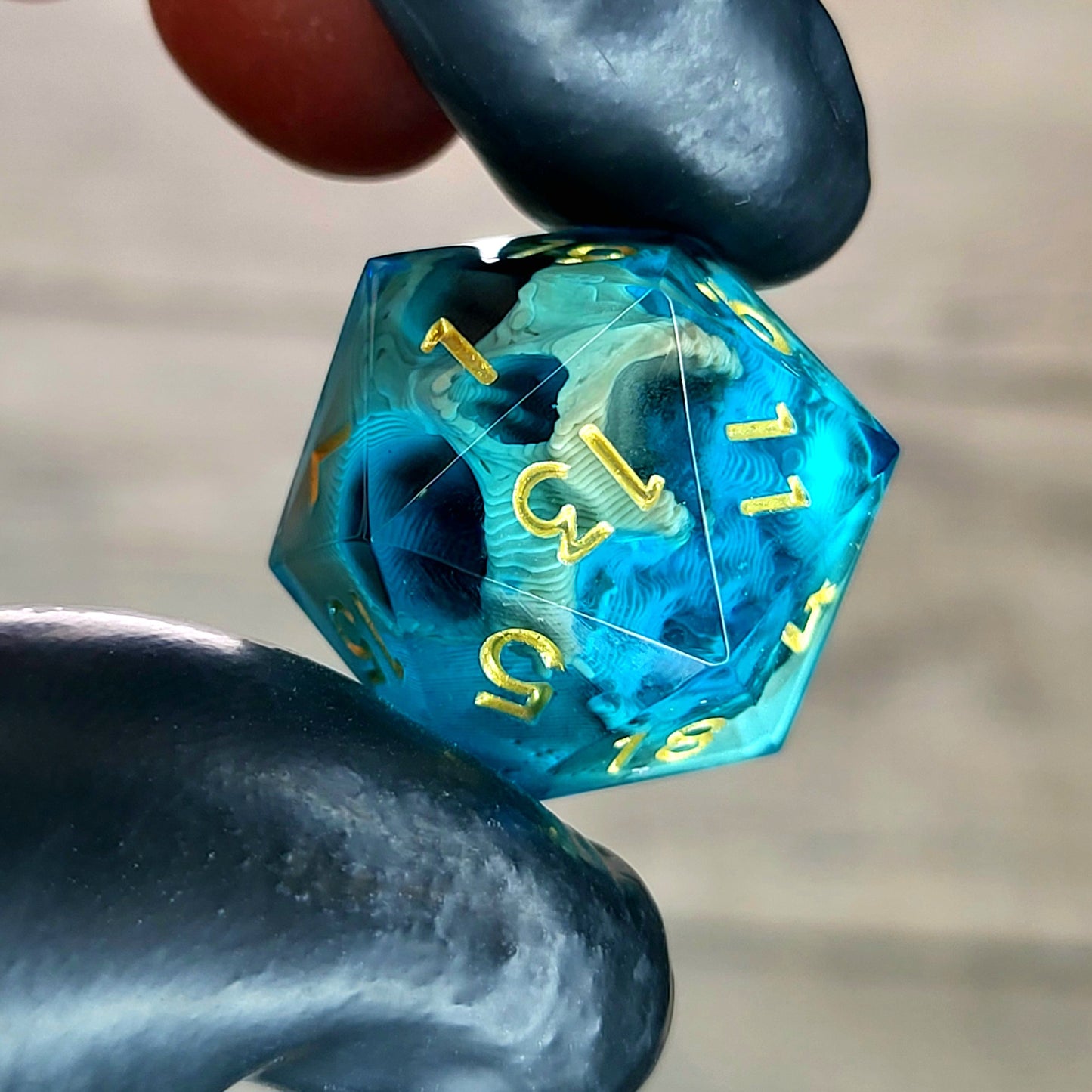 This is a single set of one D20 die with a light brown skull inside , blue resin and gold numbers for play dnd dungeons and dragons