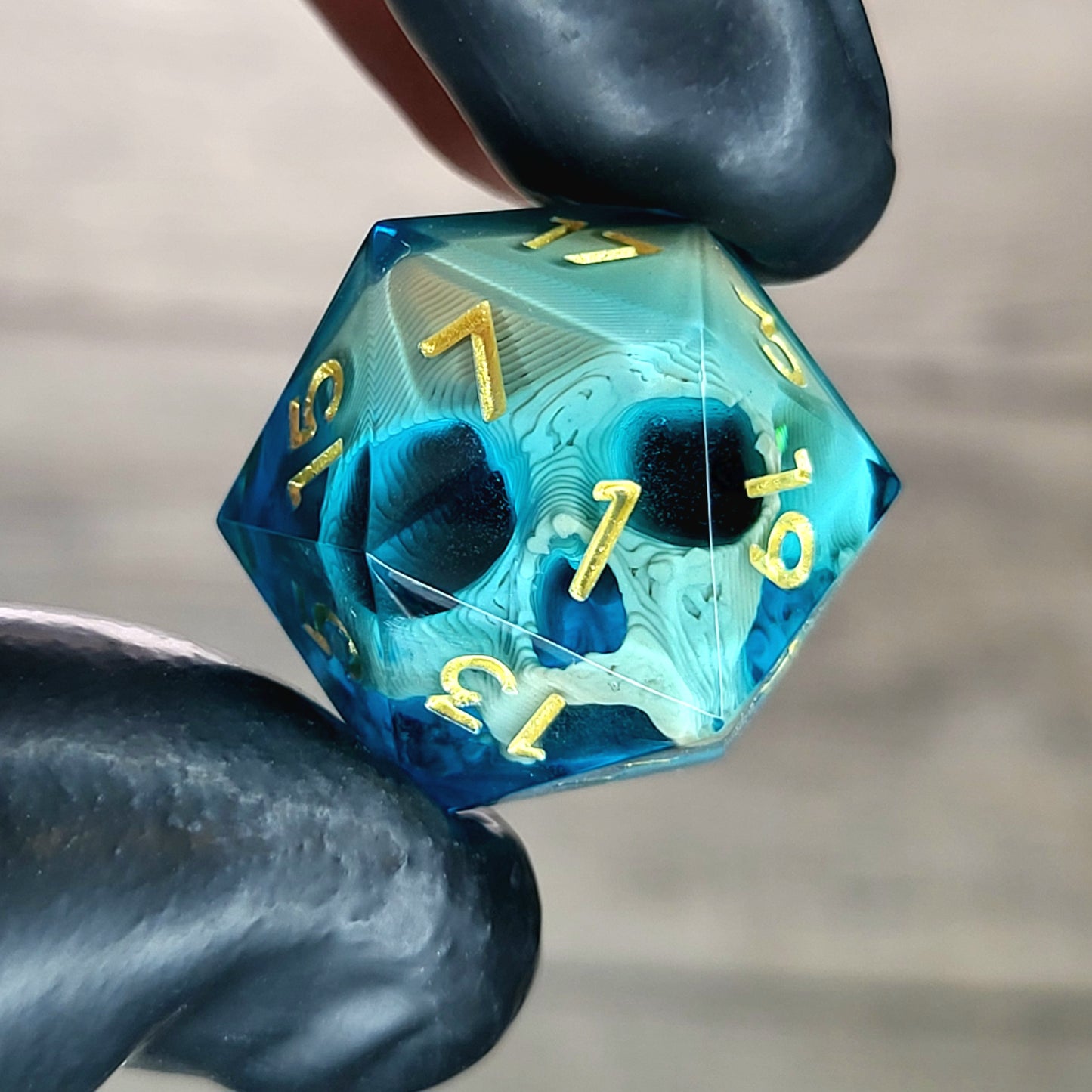 This is a single set of one D20 die with a light brown skull inside , blue resin and gold numbers for play dnd dungeons and dragons