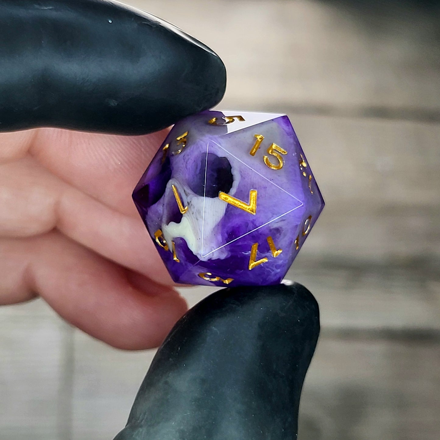 This is a single set of one D20 DnD die with a light brown skull inside , purple resin and gold numbers