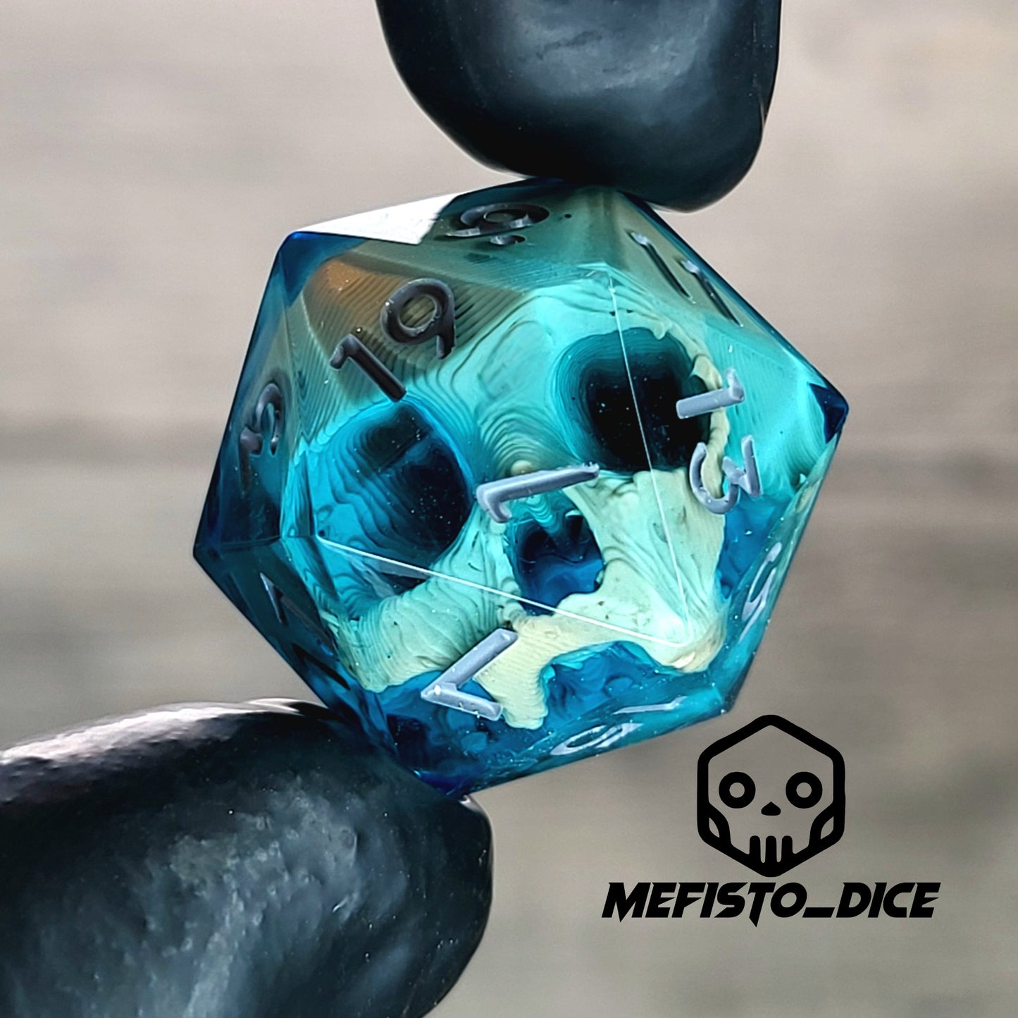 This is a single set of one D20 DnD die with a light yellow skull inside , blue resin and grey numbers