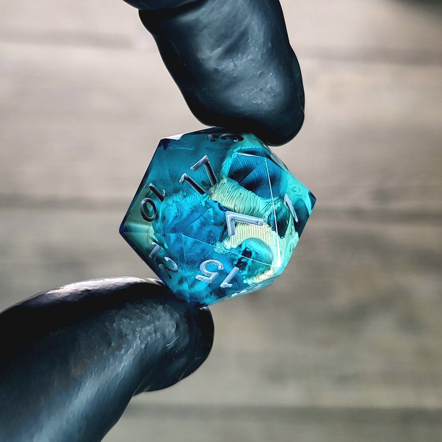 This is a single set of one D20 DnD die with a light yellow skull inside , blue resin and grey numbers