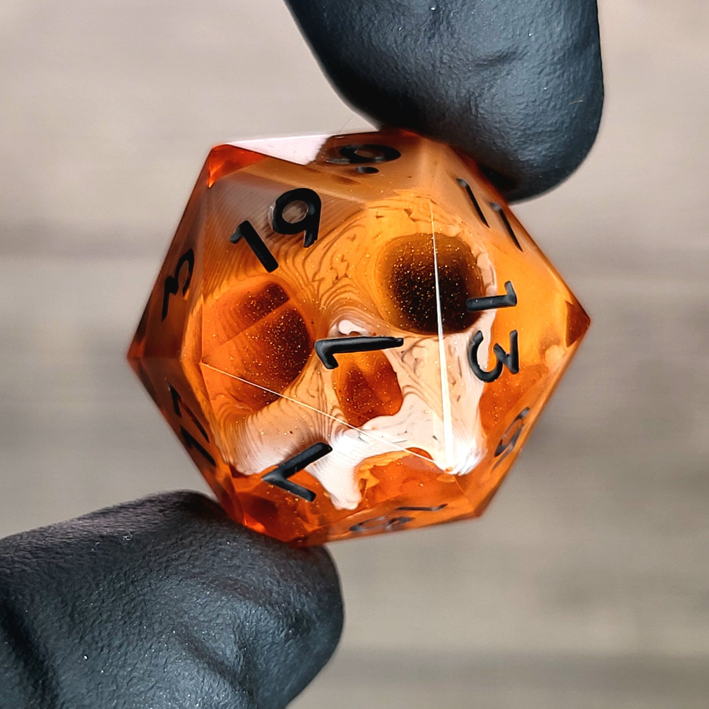 This is a single set of one D20 DnD die with a white skull inside , orange resin and black numbers