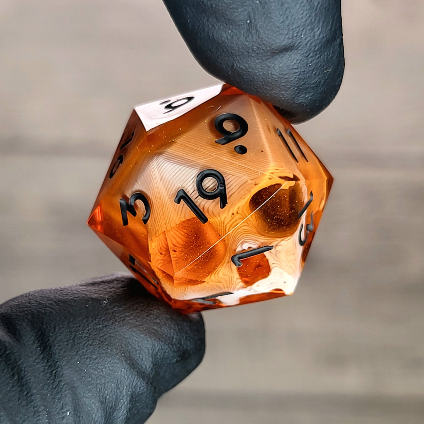 This is a single set of one D20 DnD die with a white skull inside , orange resin and black numbers