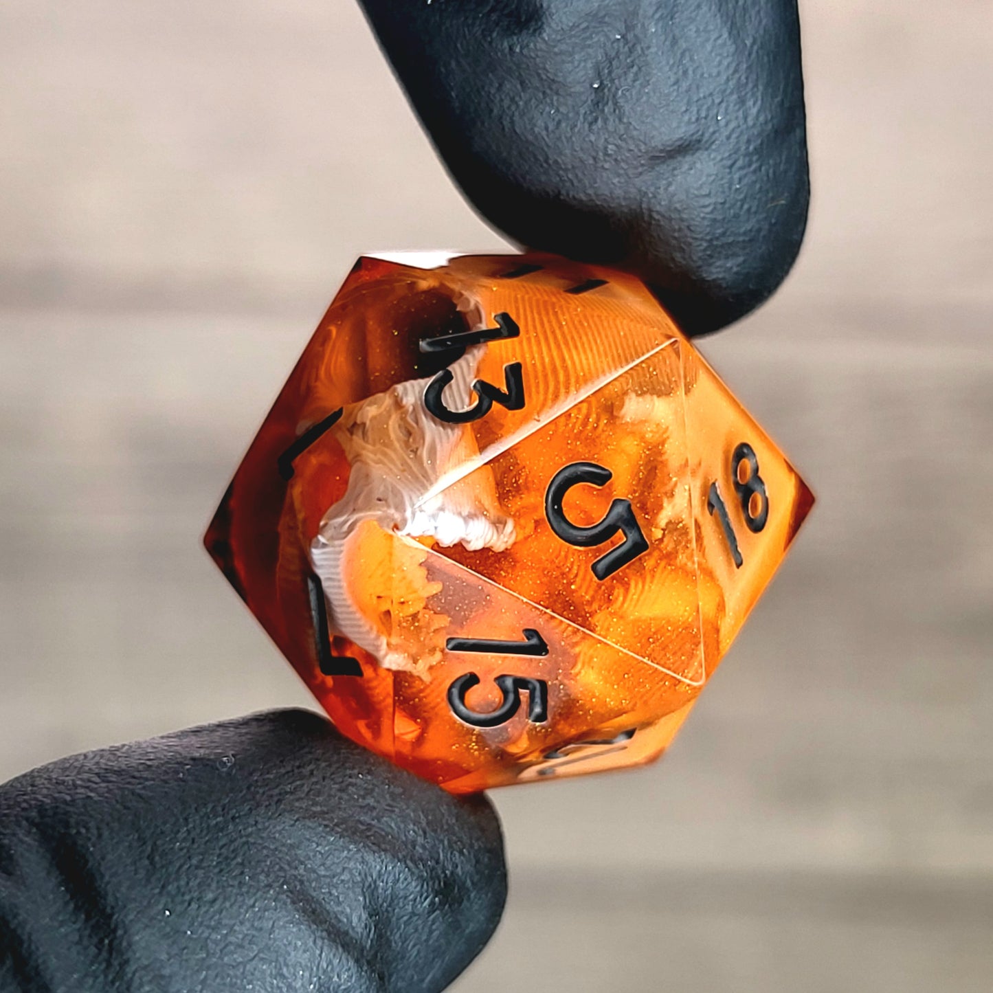 This is a single set of one D20 DnD die with a white skull inside , orange resin and black numbers