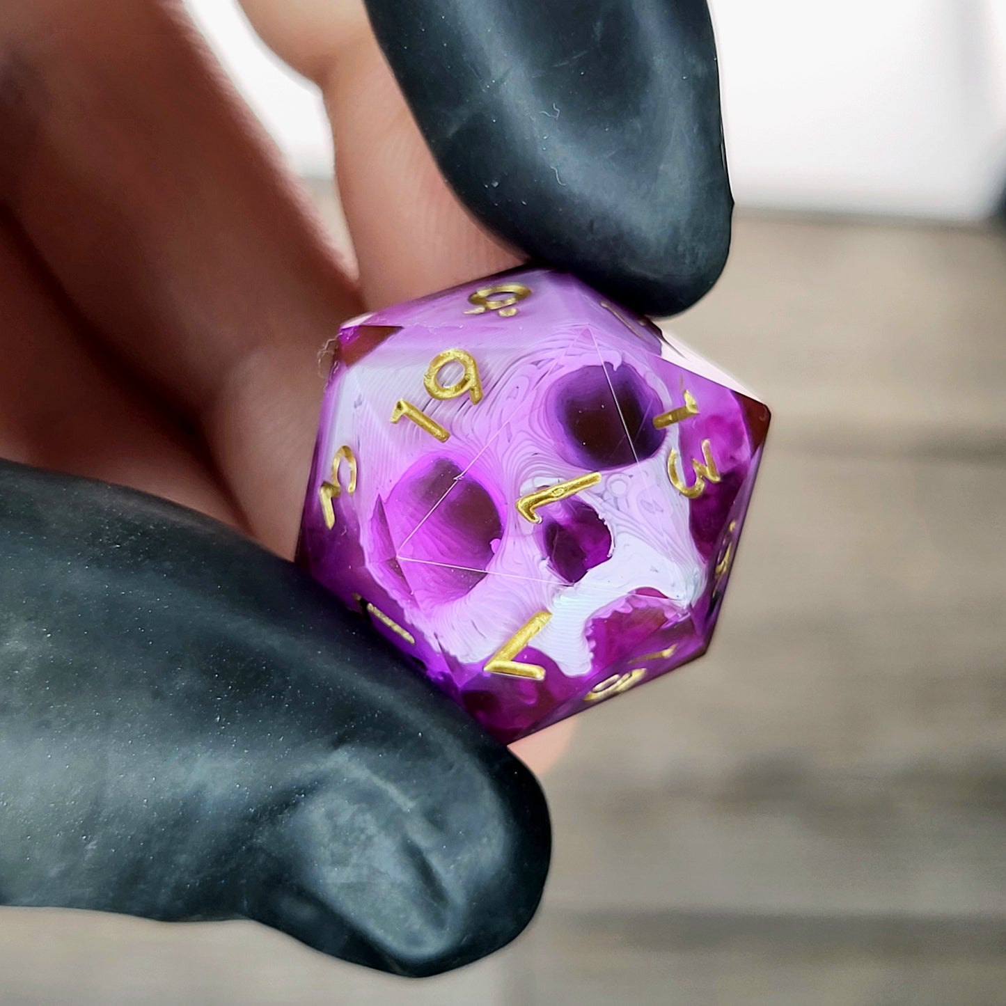 This is a single set of one D20 DnD die with a white skull inside , pink resin and gold numbers