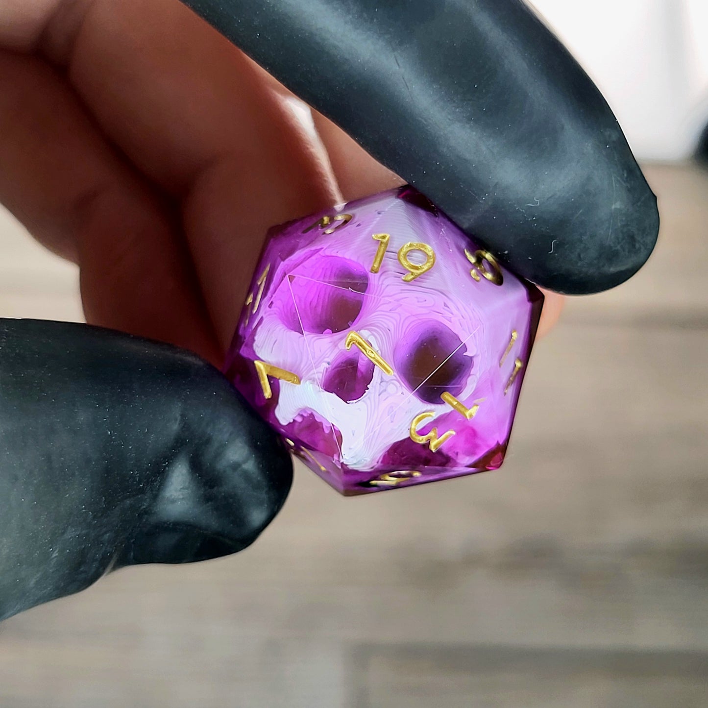 This is a single set of one D20 DnD die with a white skull inside , pink resin and gold numbers