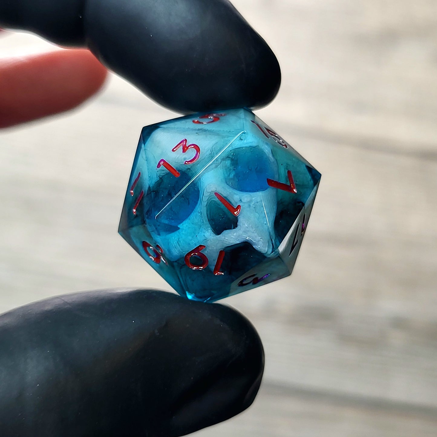 This is a single set of one D20 DnD die with a white fluo skull inside , dark resin and red numbers