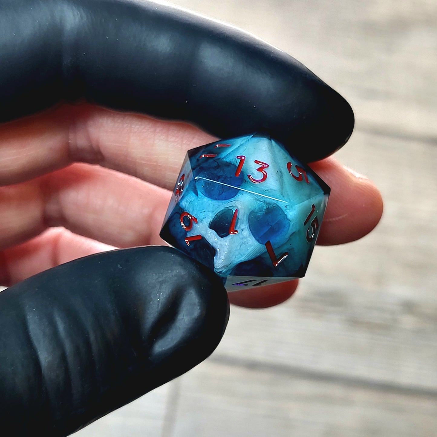 This is a single set of one D20 DnD die with a white fluo skull inside , dark resin and red numbers