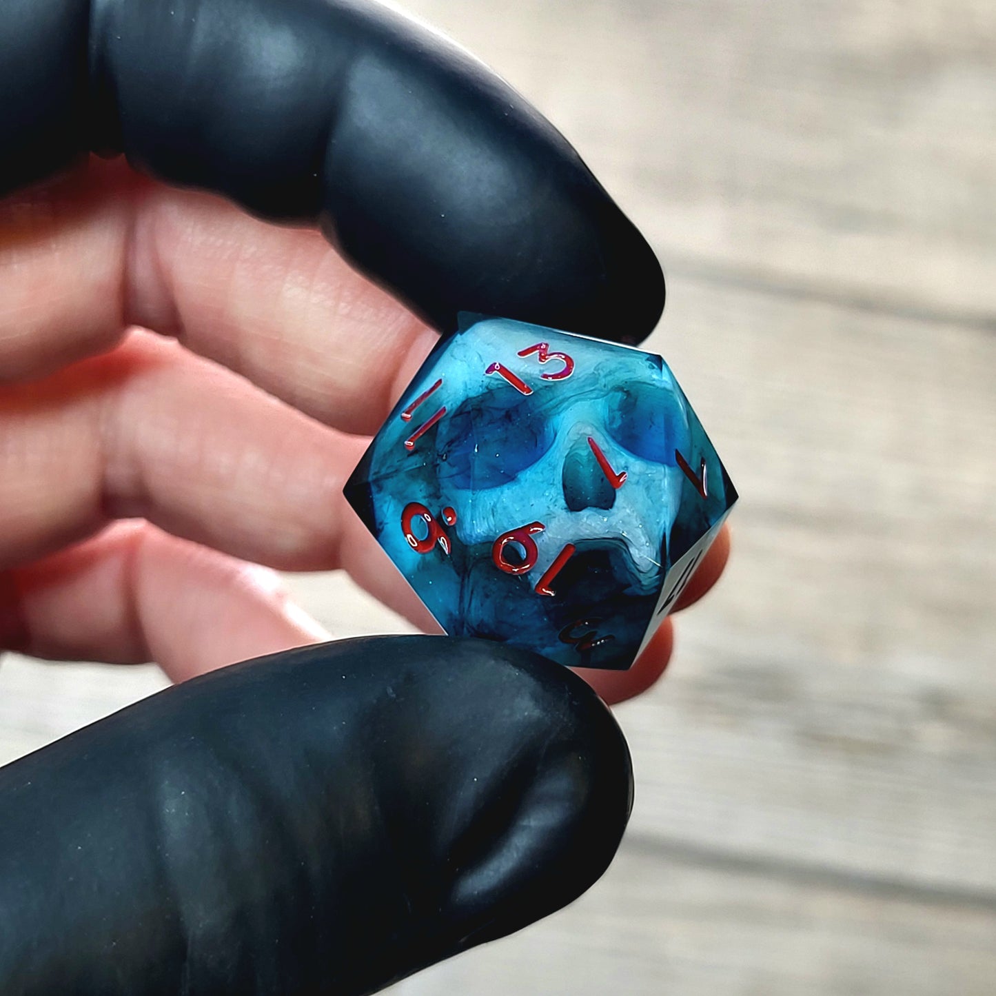 This is a single set of one D20 DnD die with a white fluo skull inside , dark resin and red numbers