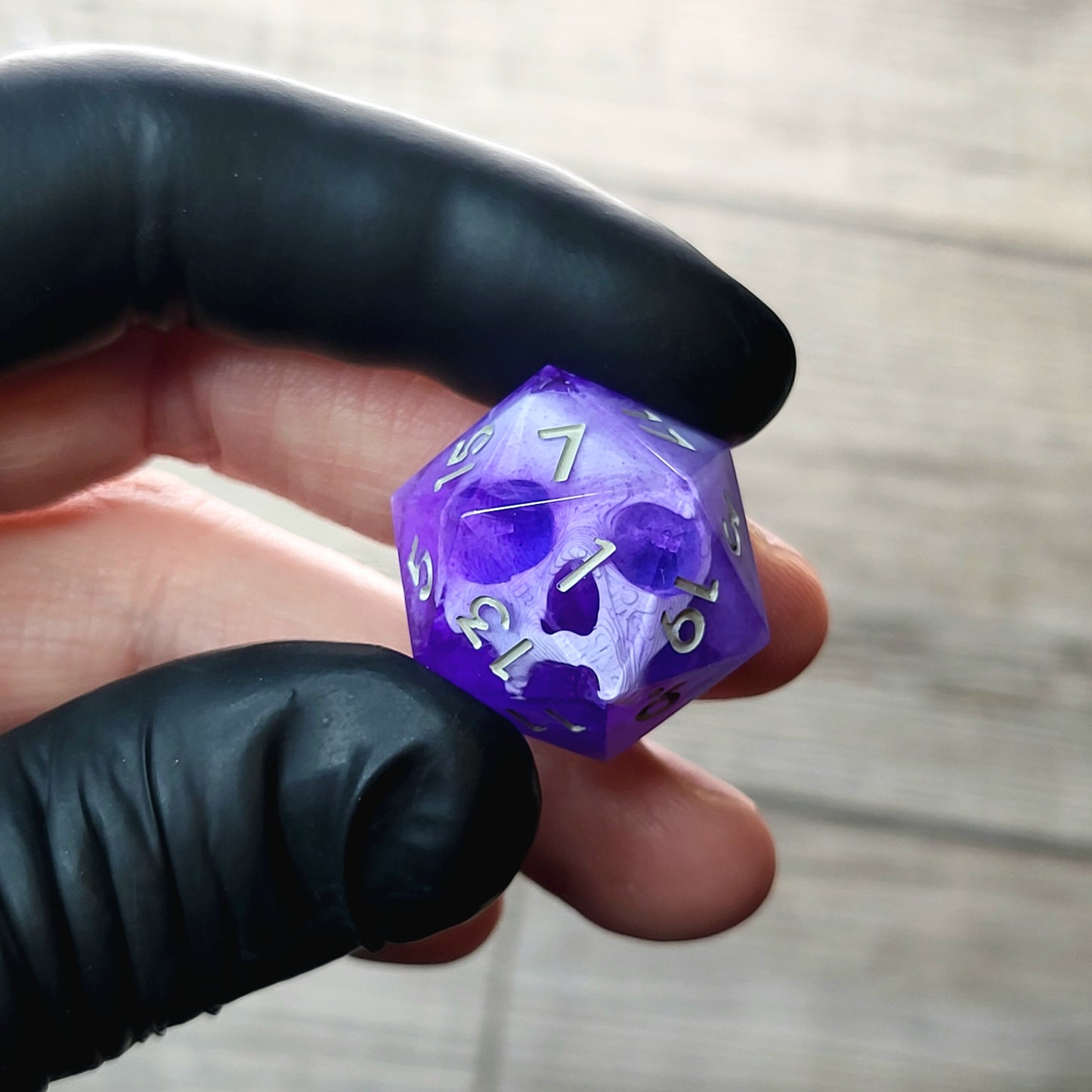 This is a single set of one D20 DnD die with a white skull inside , purple resin and grey numbers