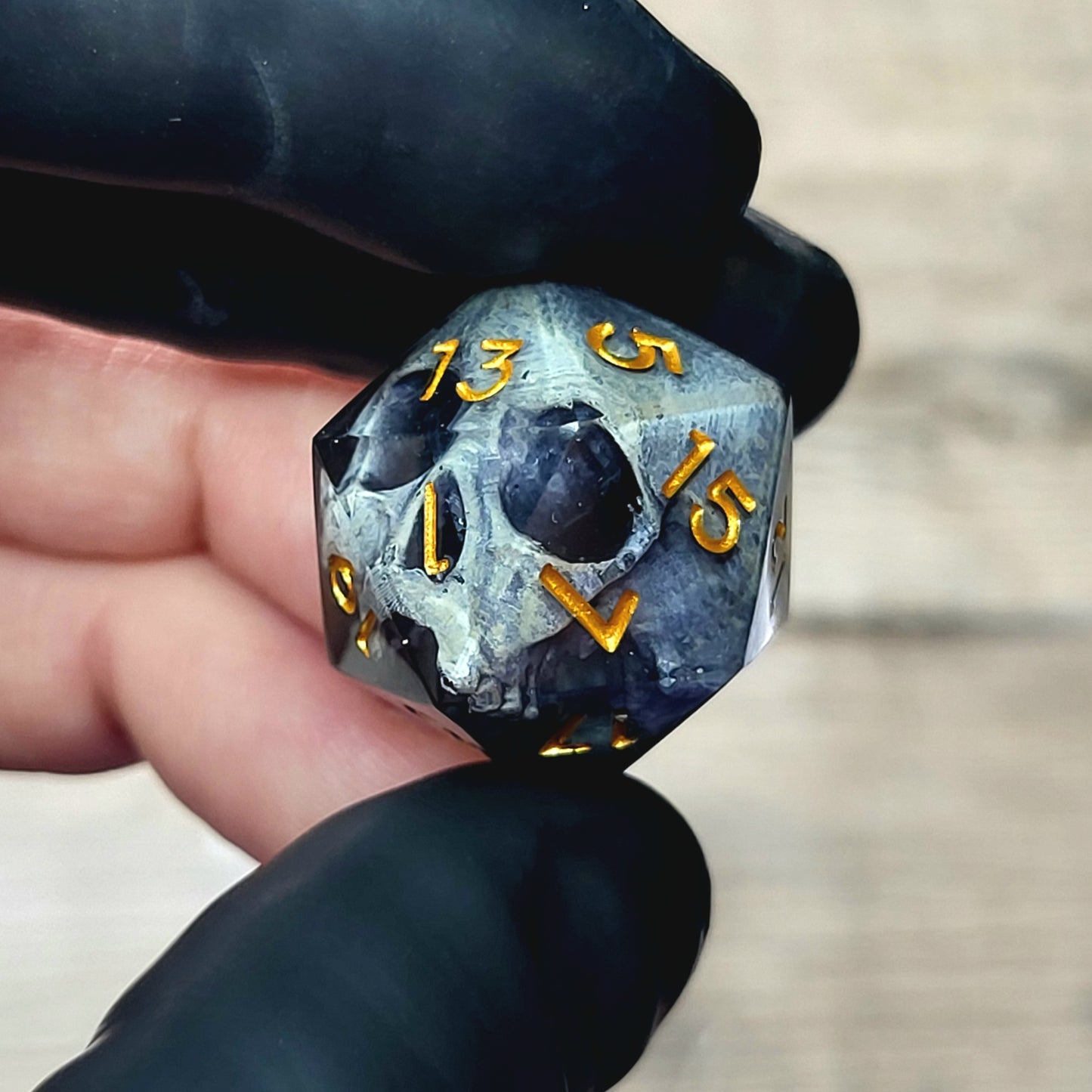 This is a single set of one D20 DnD die with a grey stone skull inside , black resin and gold numbers