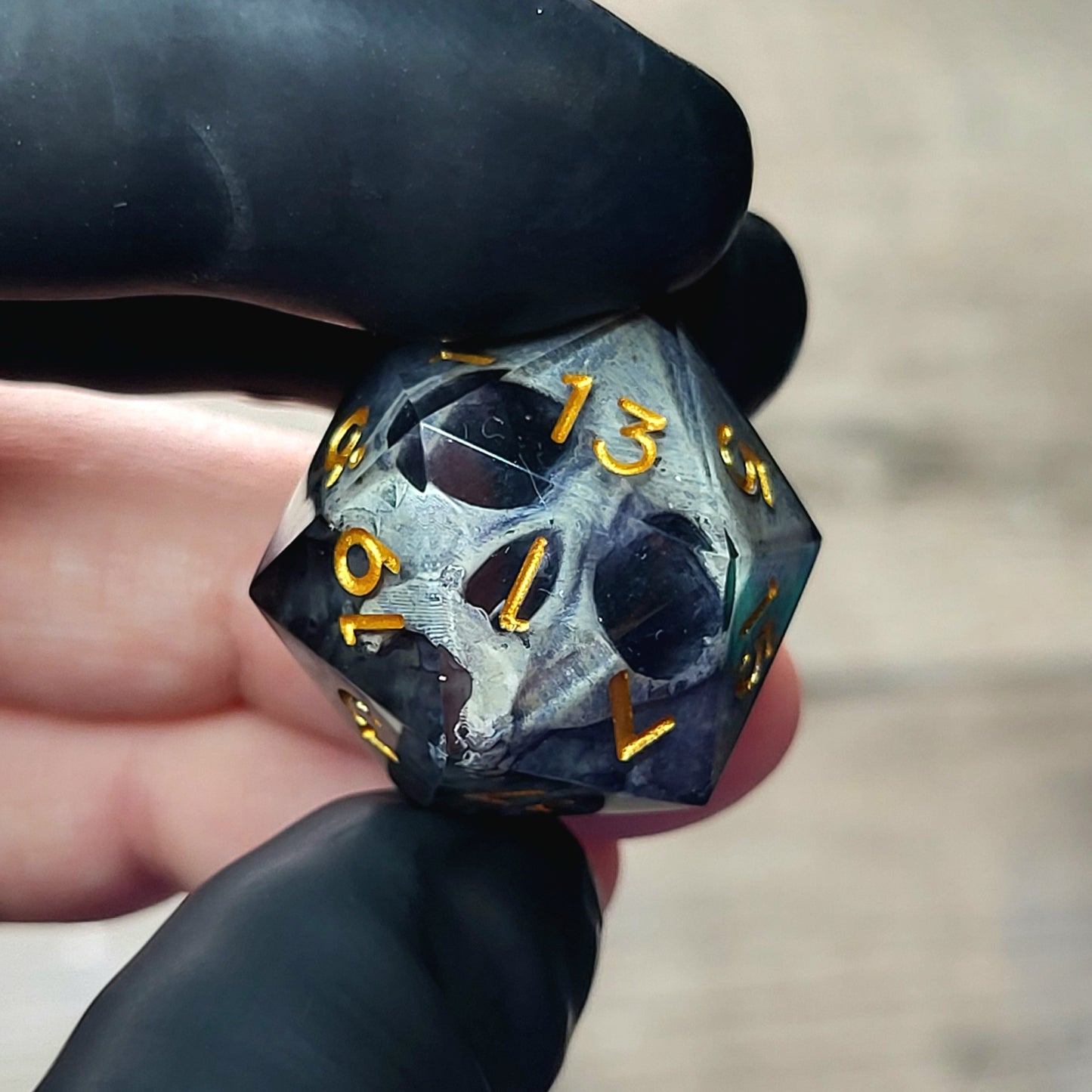 This is a single set of one D20 DnD die with a grey stone skull inside , black resin and gold numbers