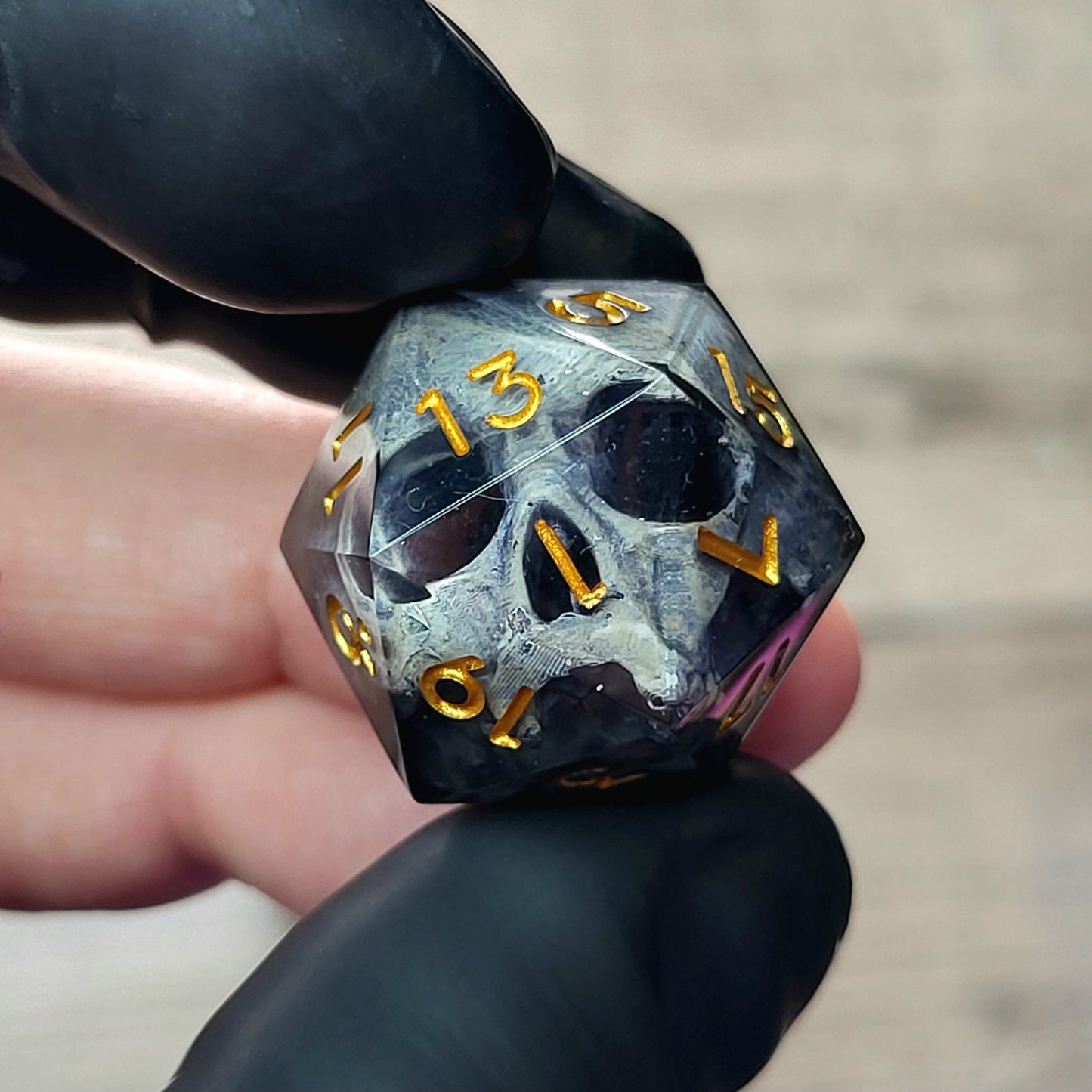 This is a single set of one D20 DnD die with a grey stone skull inside , black resin and gold numbers
