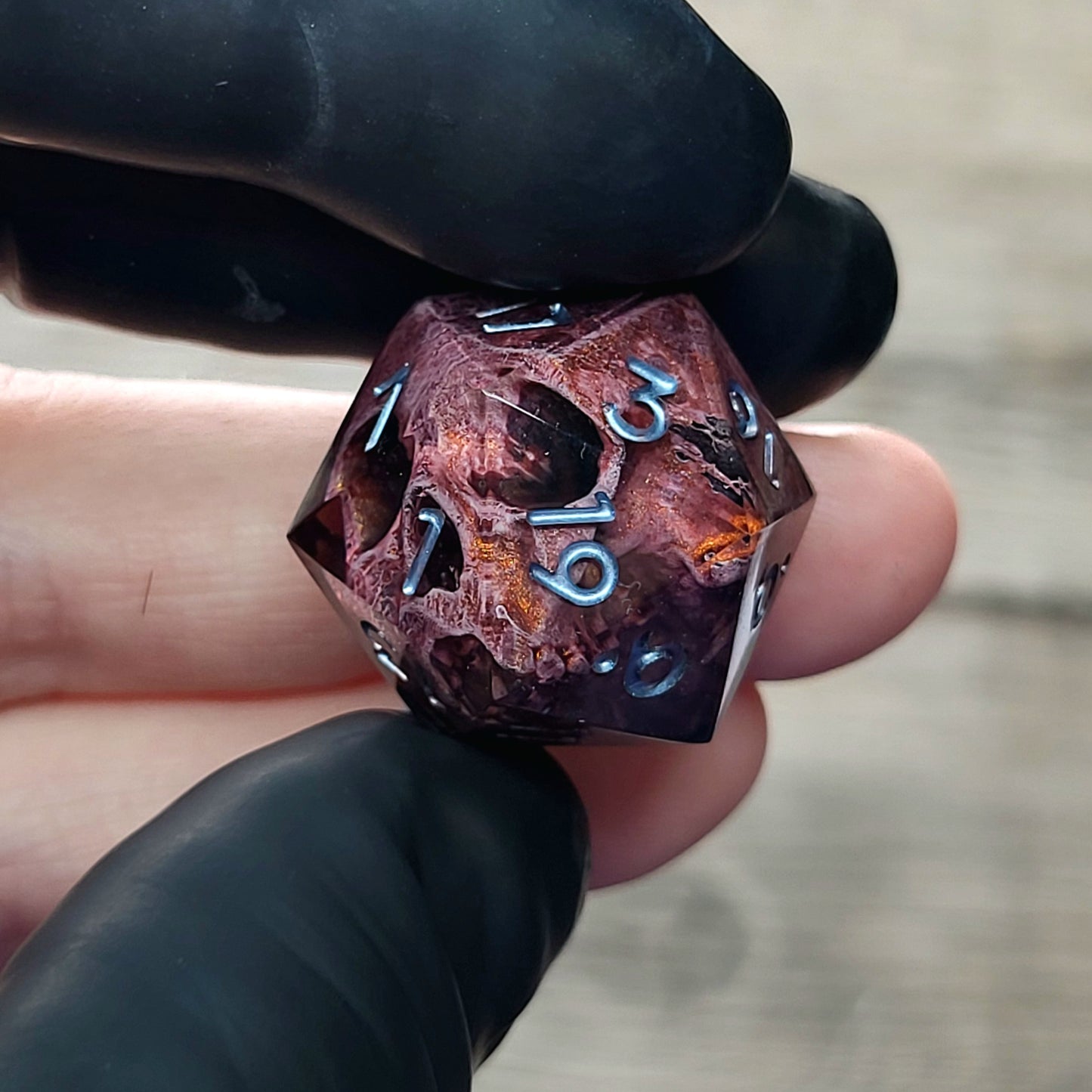 This is a single set of one D20 DnD die with a bronze skull inside , black resin and silver numbers