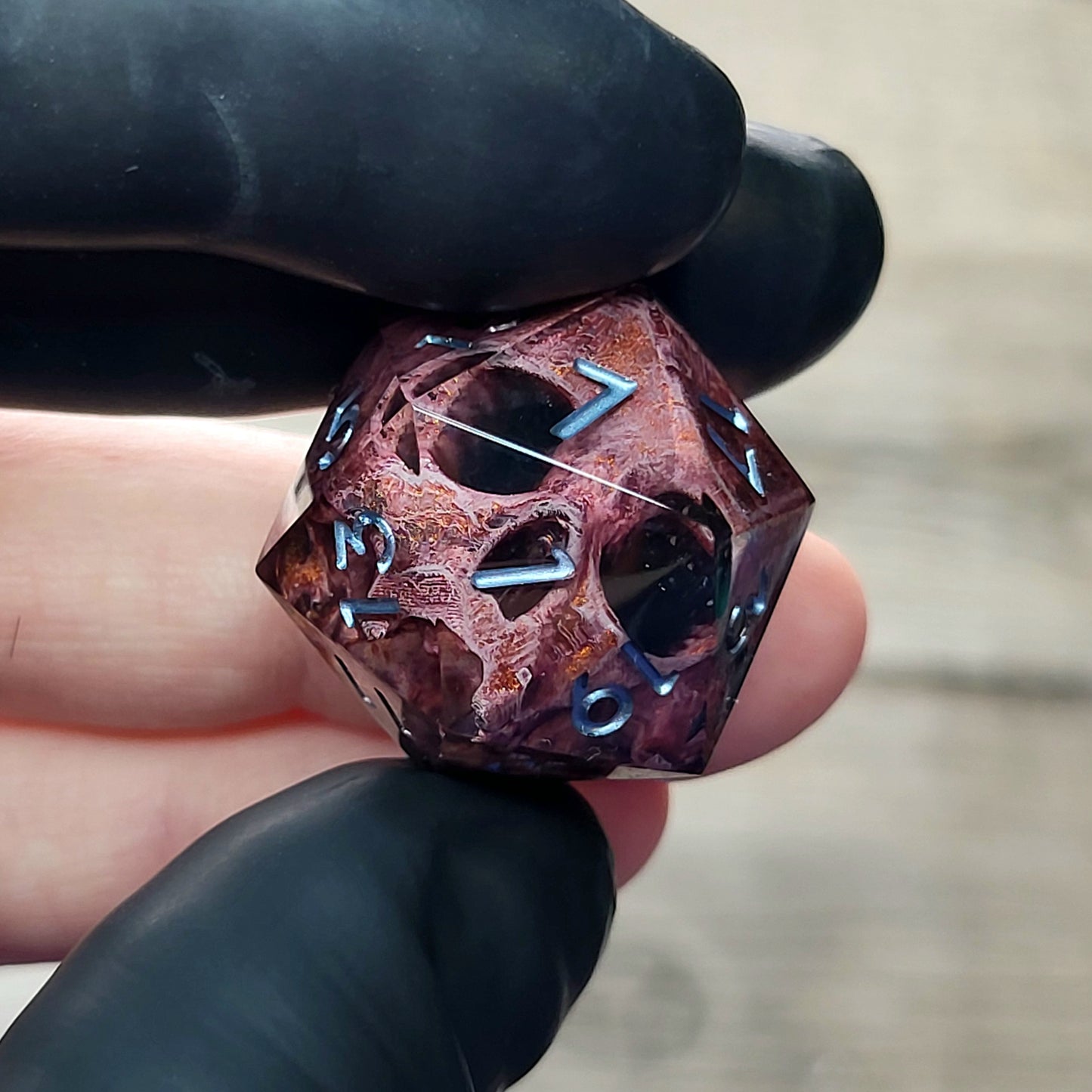This is a single set of one D20 DnD die with a bronze skull inside , black resin and silver numbers