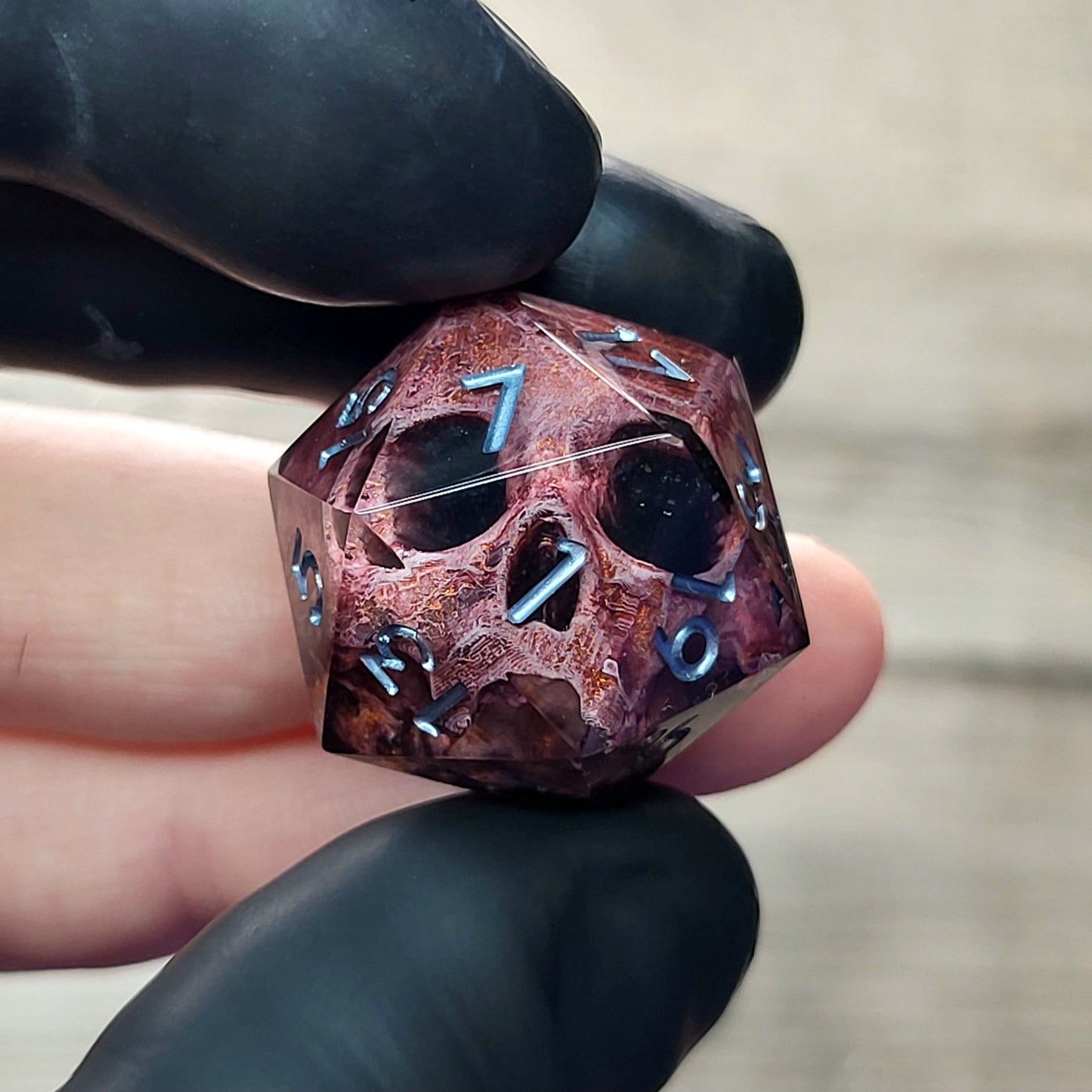 This is a single set of one D20 DnD die with a bronze skull inside , black resin and silver numbers