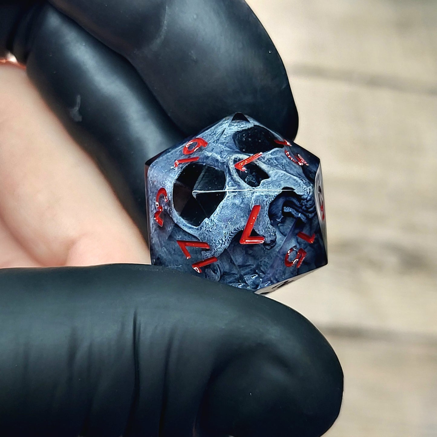 This is a single set of one D20 DnD die with a dark grey skull inside ,black resin and red numbers