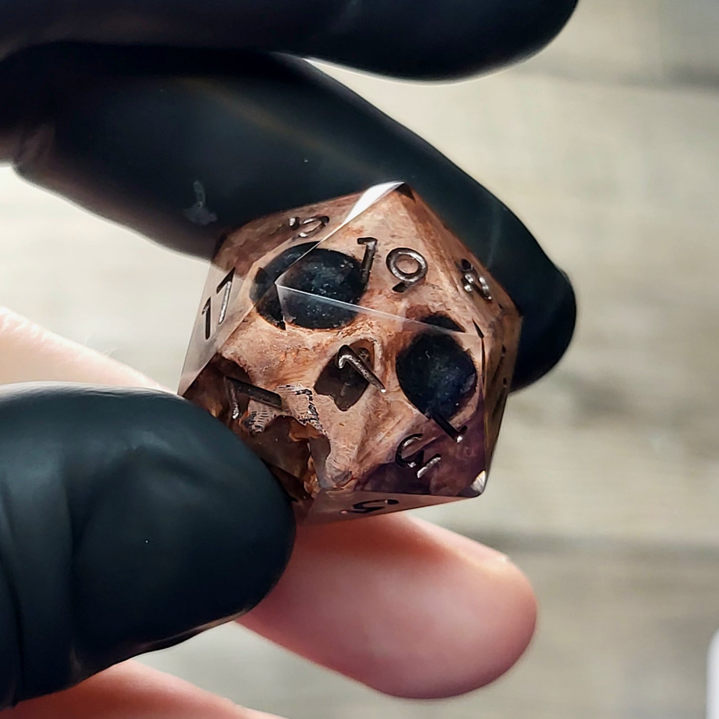 This is a single set of one D20 DnD die with a light brown skull inside ,black resin and dark bronze numbers