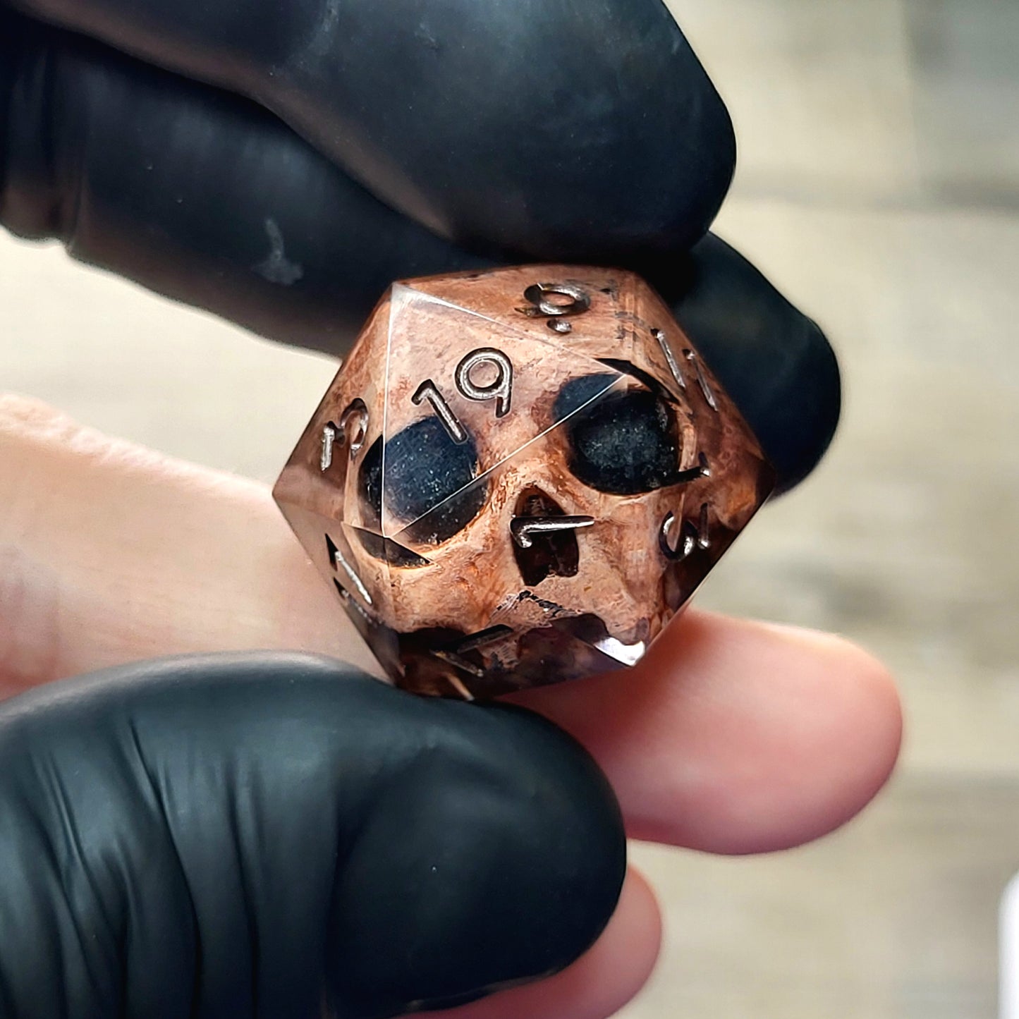 This is a single set of one D20 DnD die with a light brown skull inside ,black resin and dark bronze numbers