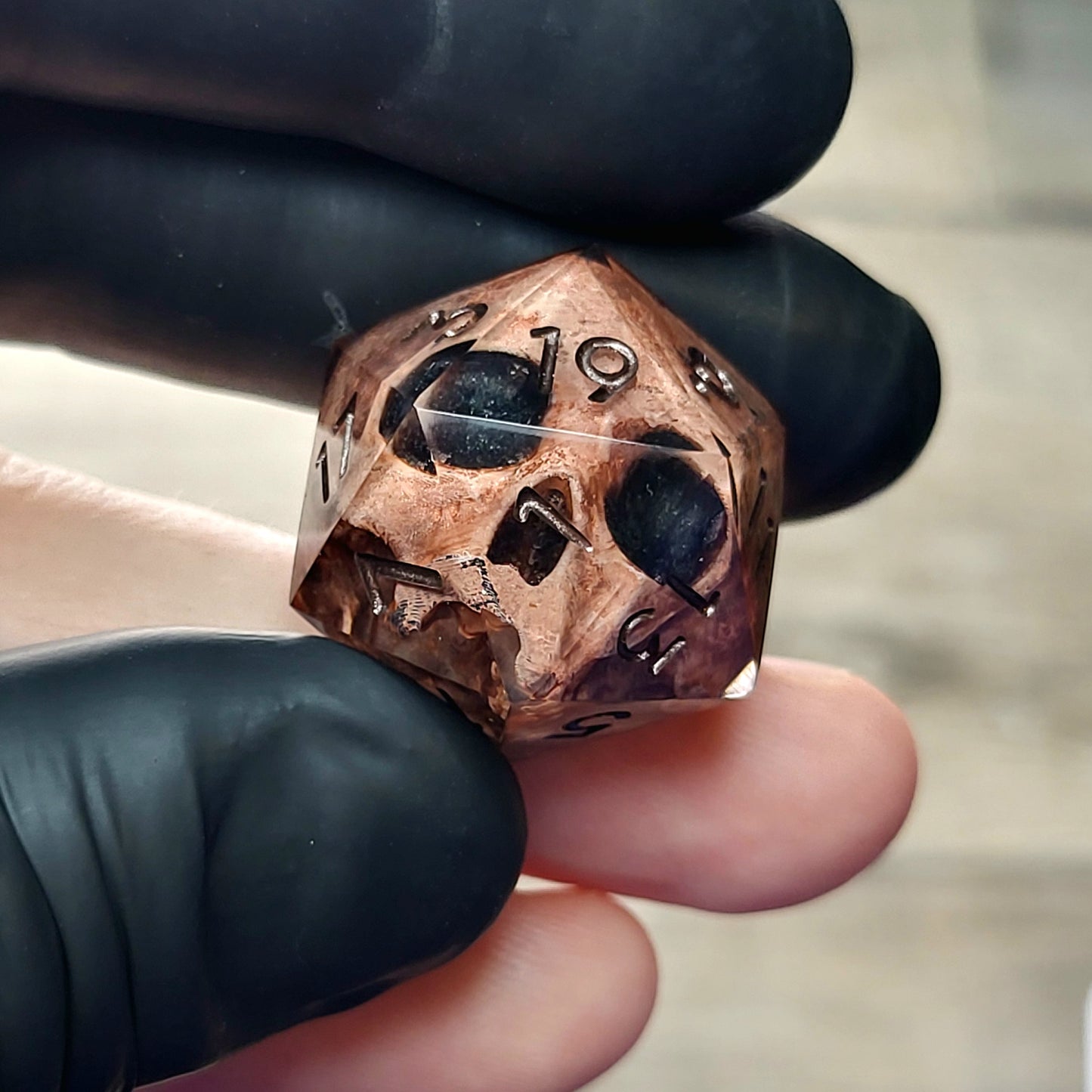 This is a single set of one D20 DnD die with a light brown skull inside ,black resin and dark bronze numbers