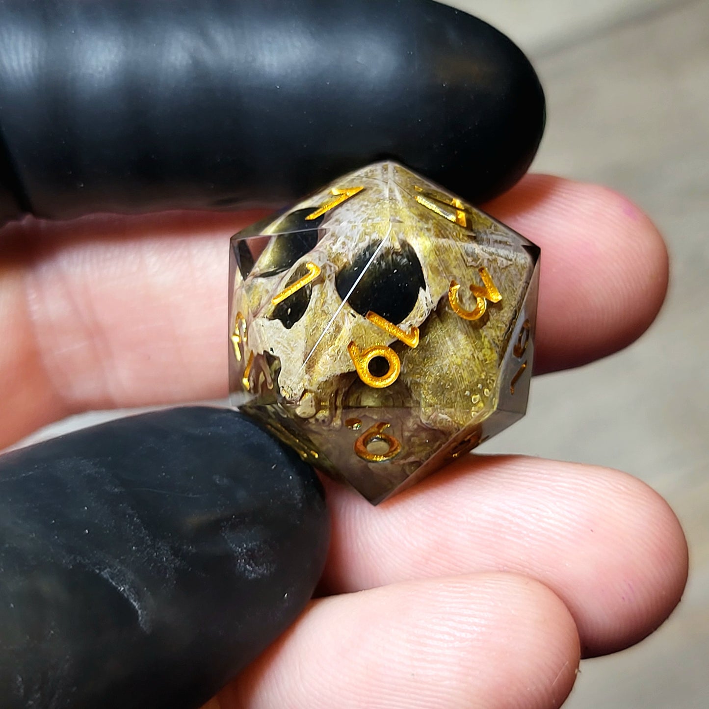 This is a single set of one D20 DND die with a light brown skull inside ,black resin and gold numbers