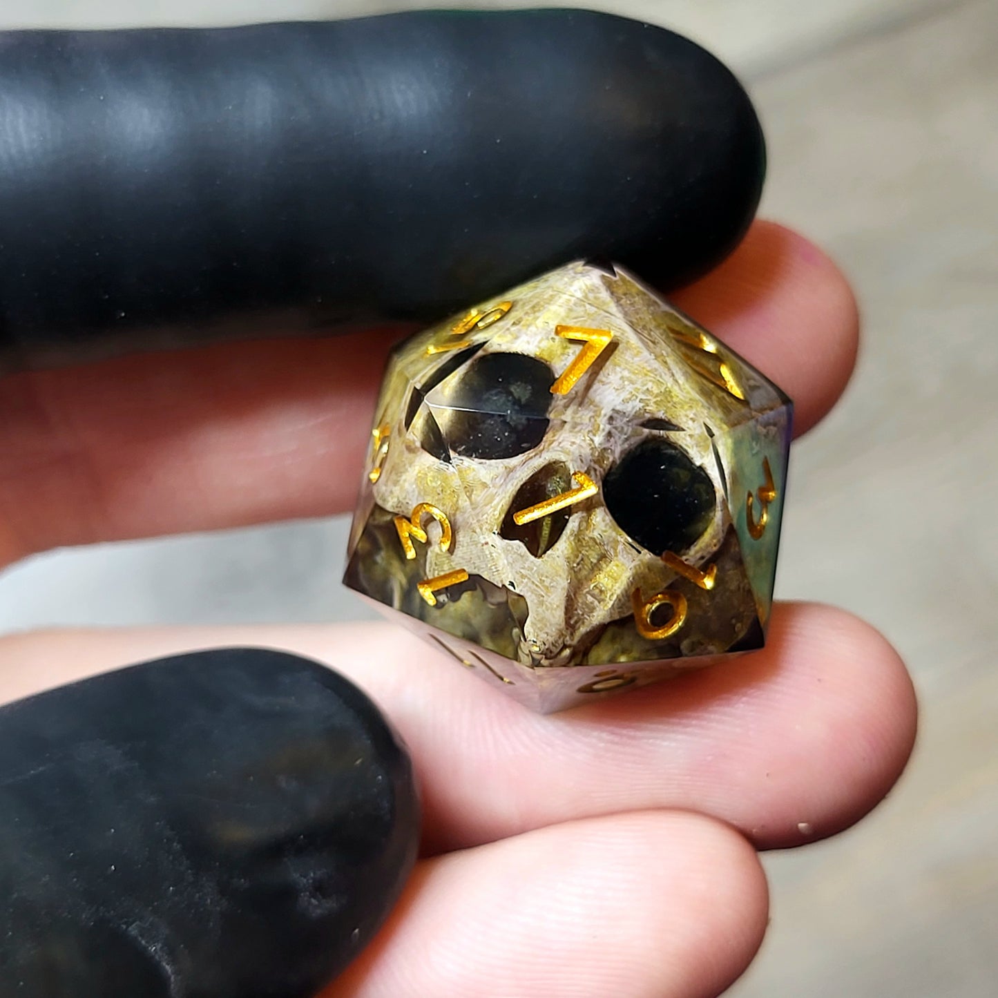 This is a single set of one D20 DND die with a light brown skull inside ,black resin and gold numbers