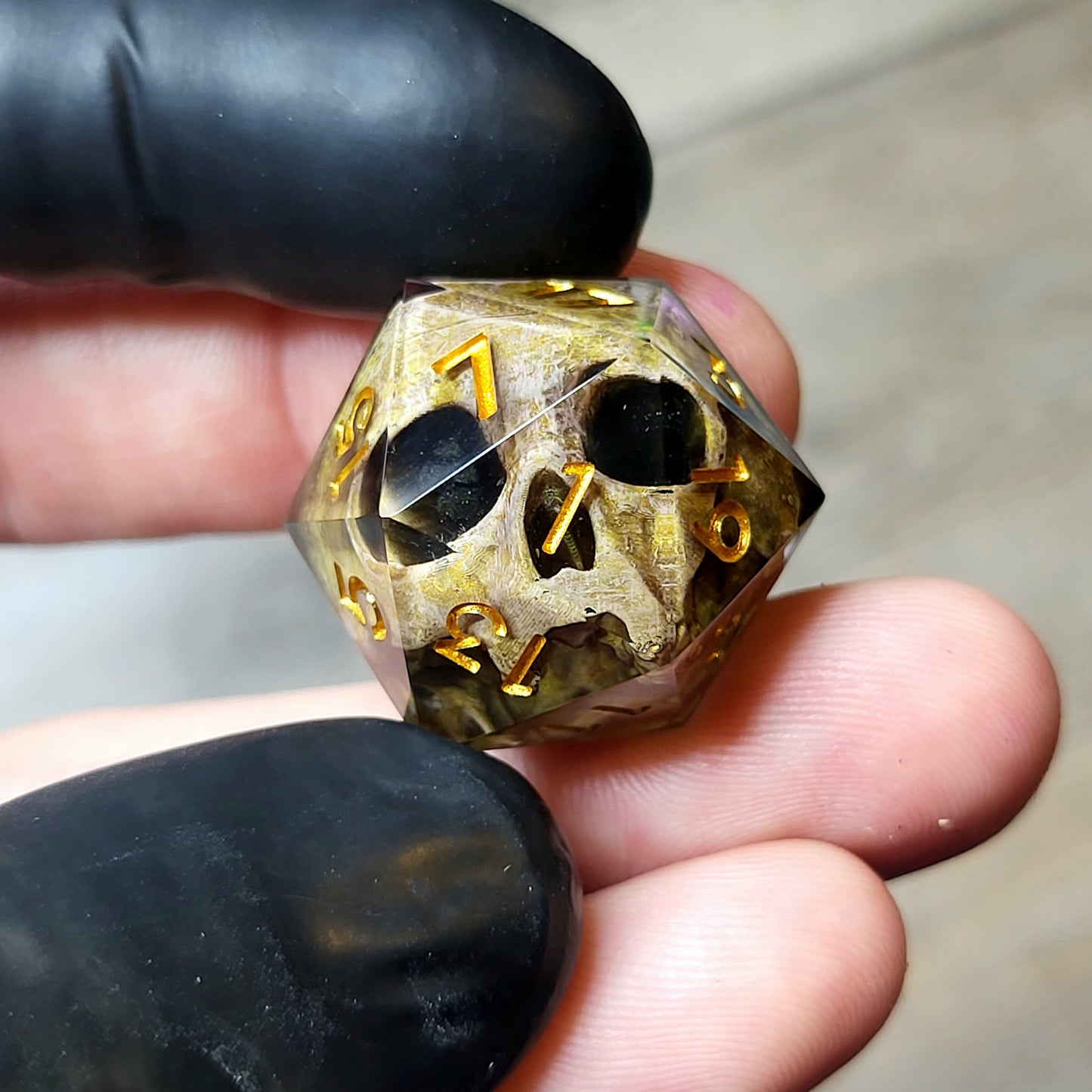 This is a single set of one D20 DND die with a light brown skull inside ,black resin and gold numbers