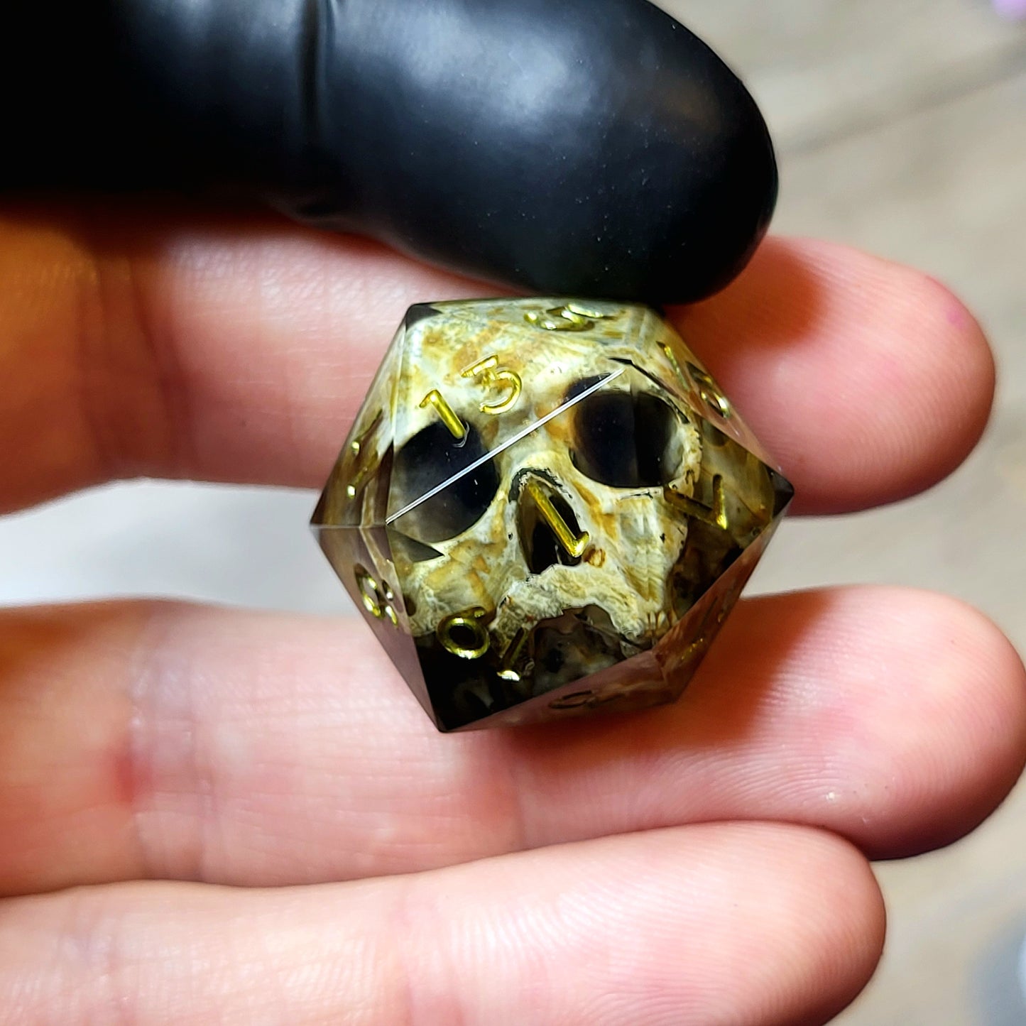This is a single set of one D20 DND die with a light brown skull inside ,black resin and green gold numbers