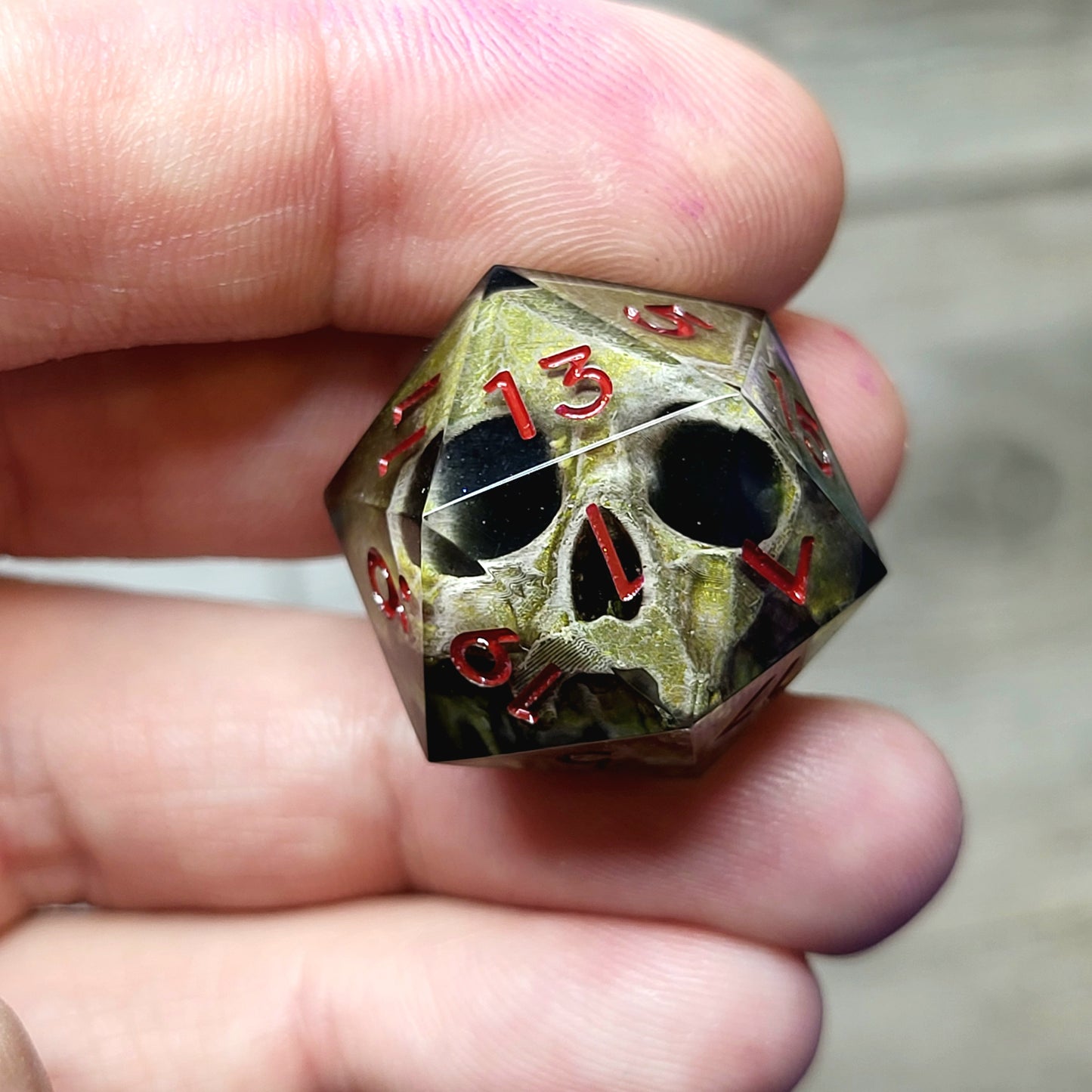 This is a single set of one D20 DND die with a light brown skull inside ,black resin and red numbers