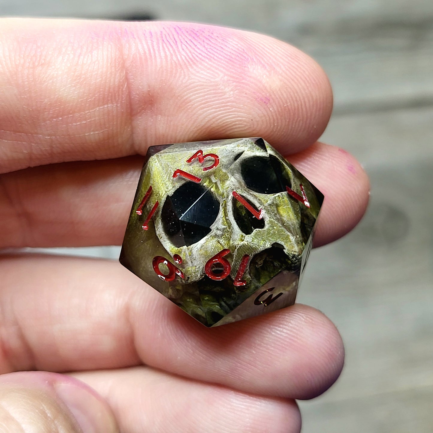 This is a single set of one D20 DND die with a light brown skull inside ,black resin and red numbers