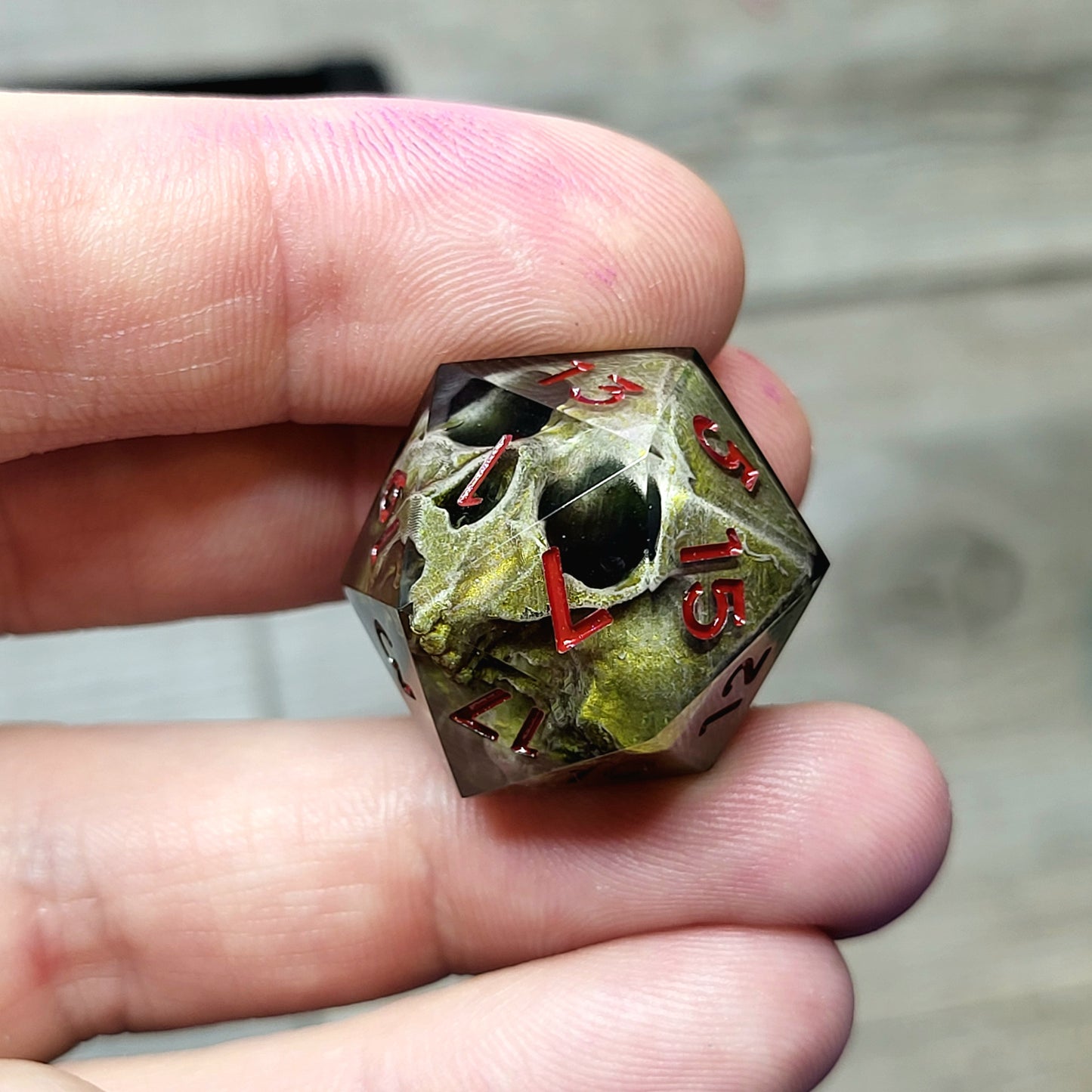 This is a single set of one D20 DND die with a light brown skull inside ,black resin and red numbers