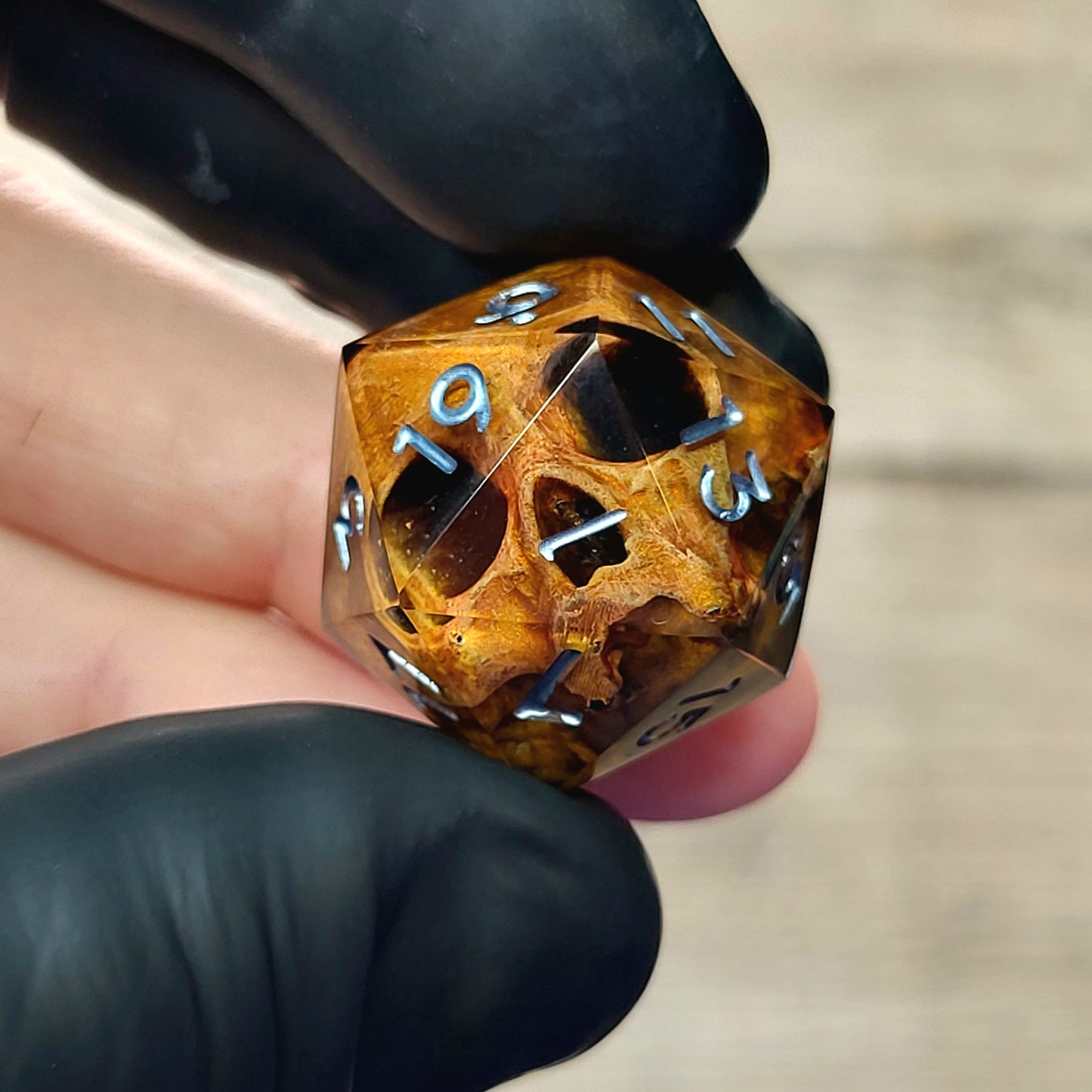 This is a single set of one D20 DnD die with a light brown skull inside , black resin and silver numbers