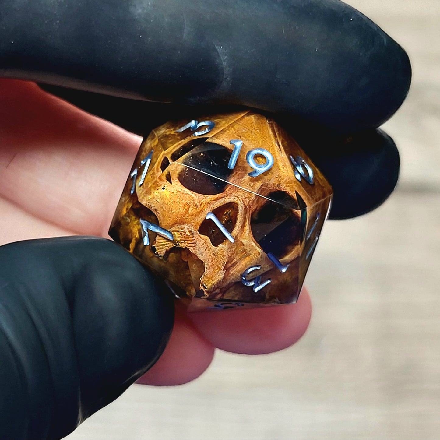 This is a single set of one D20 DnD die with a light brown skull inside , black resin and silver numbers