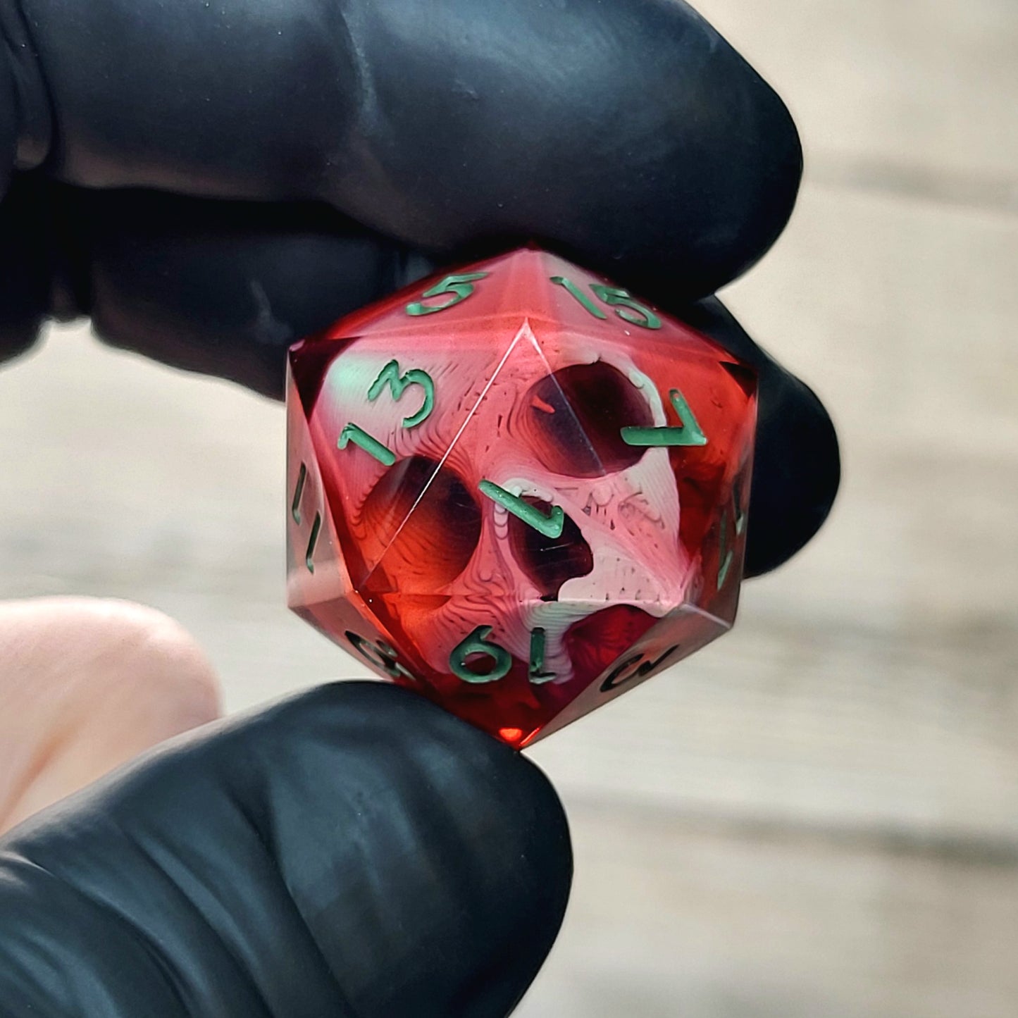 This is a single set of one D20 DnD die with a light green skull inside , red resin and green numbers