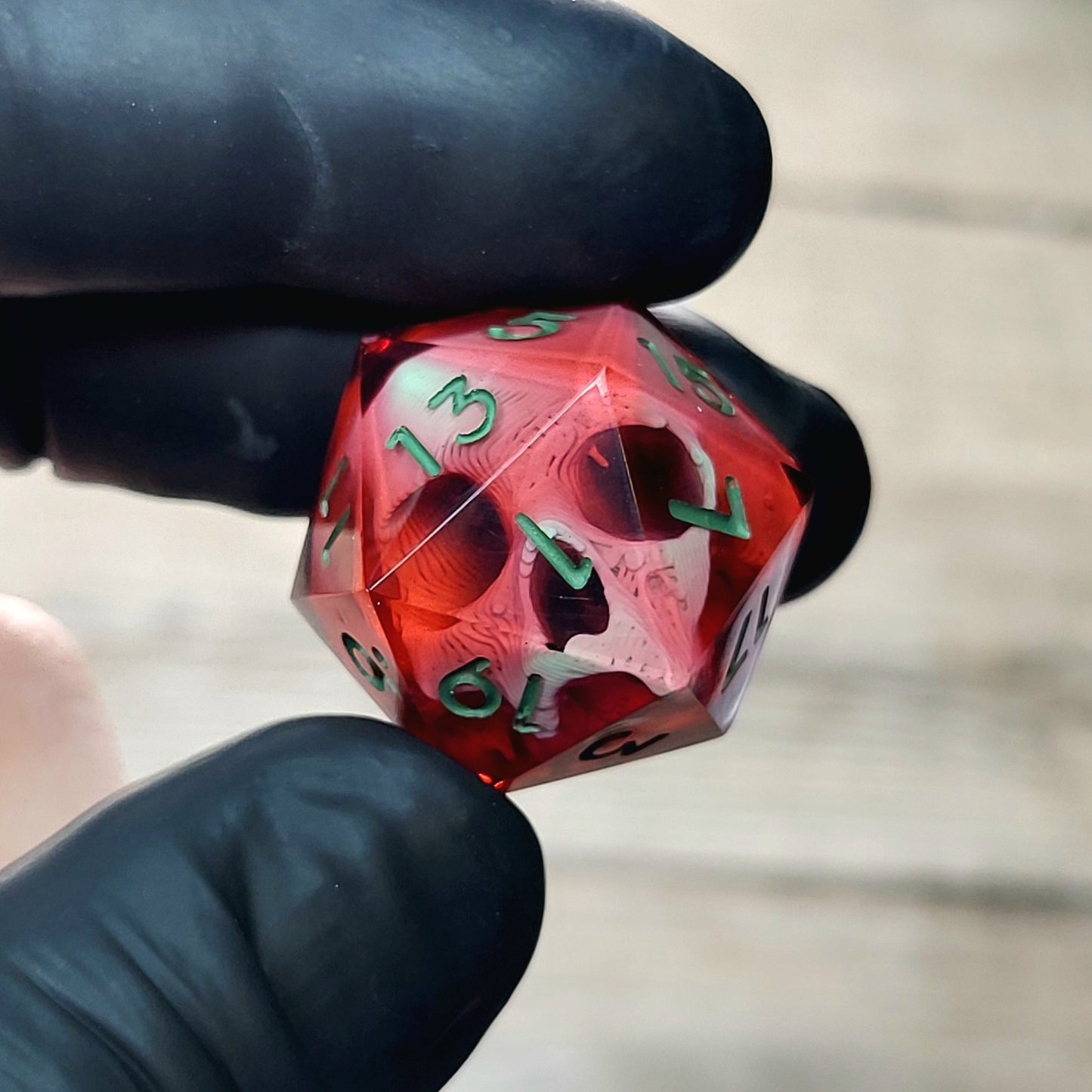 This is a single set of one D20 DnD die with a light green skull inside , red resin and green numbers
