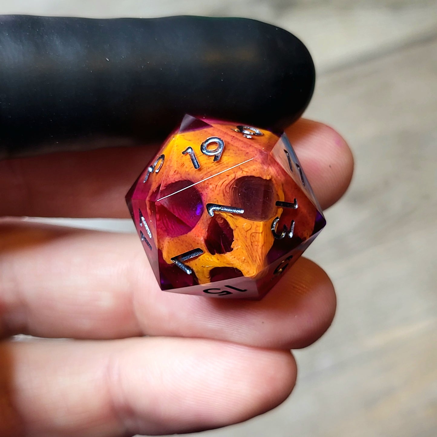 This is a single set of one D20 DND die with a orange skull inside ,purple resin and black silver numbers