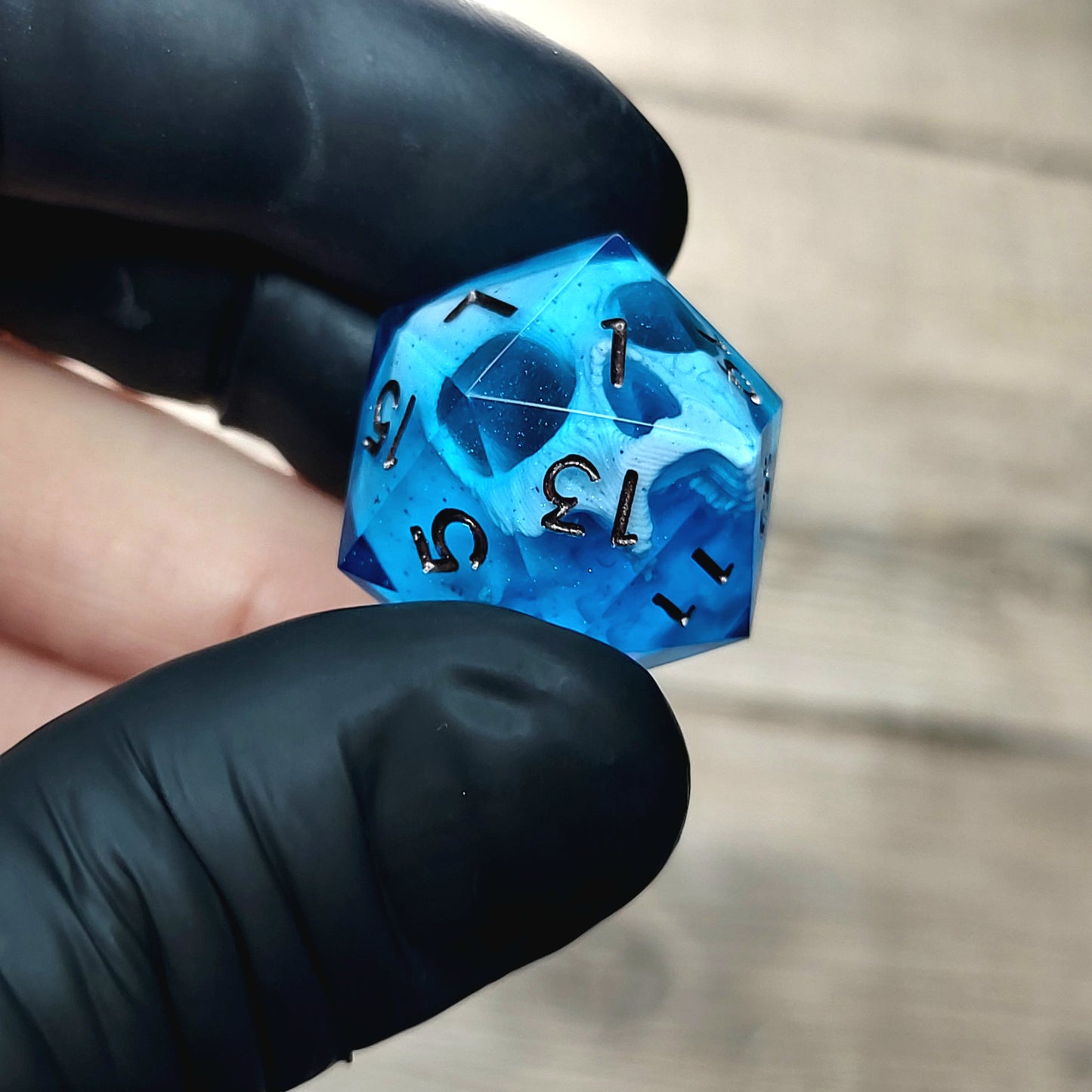 This is a single set of one D20 DnD die with a white skull inside ,blue resin and metal dark numbers