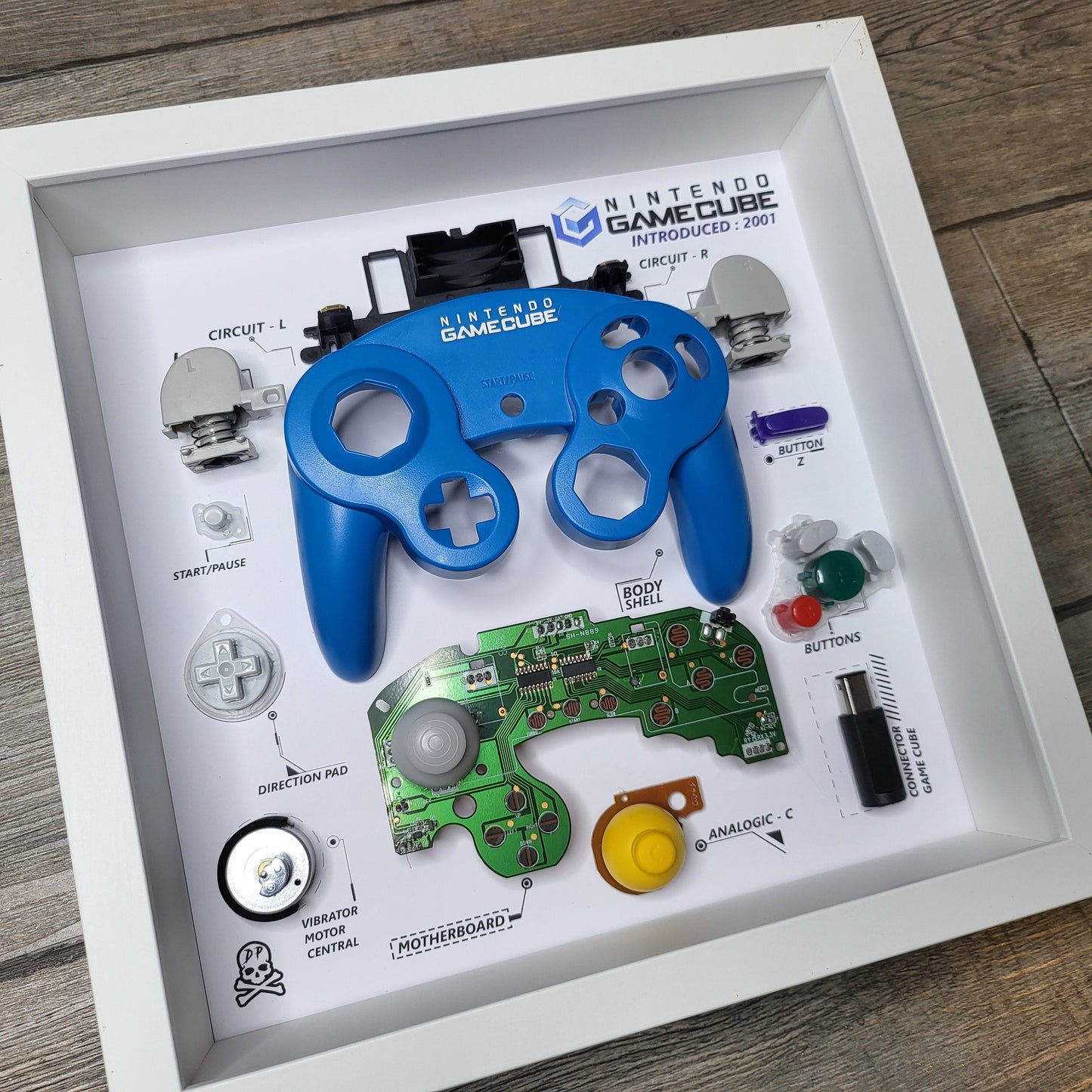 Shadow Box 10x10 with wood frame and polycarbonate glass for wall and Tabletop containing a disassembled controller for Playstation and Nintendo