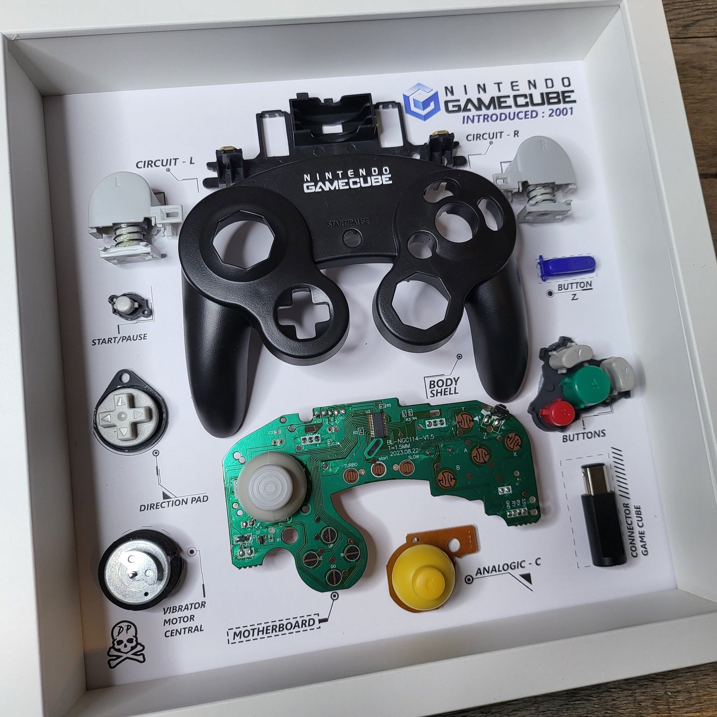 Shadow Box 10x10 with wood frame and polycarbonate glass for wall and Tabletop containing a disassembled controller for Playstation and Nintendo