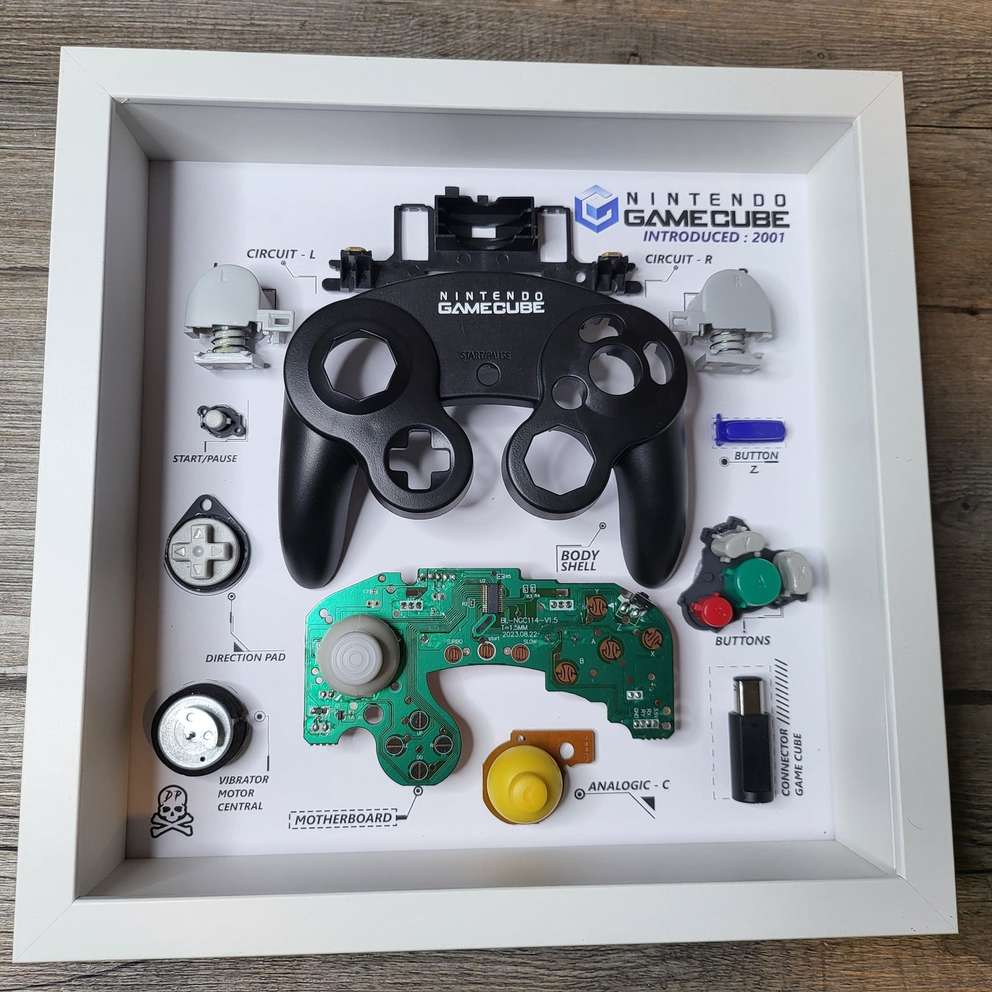 Shadow Box 10x10 with wood frame and polycarbonate glass for wall and Tabletop containing a disassembled controller for Playstation and Nintendo