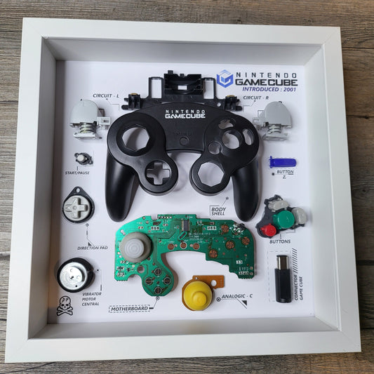 Shadow Box 10x10 with wood frame and polycarbonate glass for wall and Tabletop containing a disassembled controller for Playstation and Nintendo