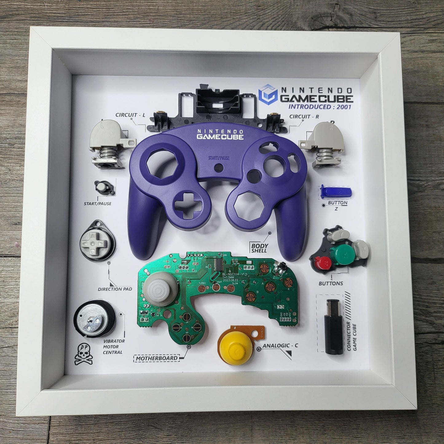 Shadow Box 10x10 with wood frame and polycarbonate glass for wall and Tabletop containing a disassembled controller for Playstation and Nintendo