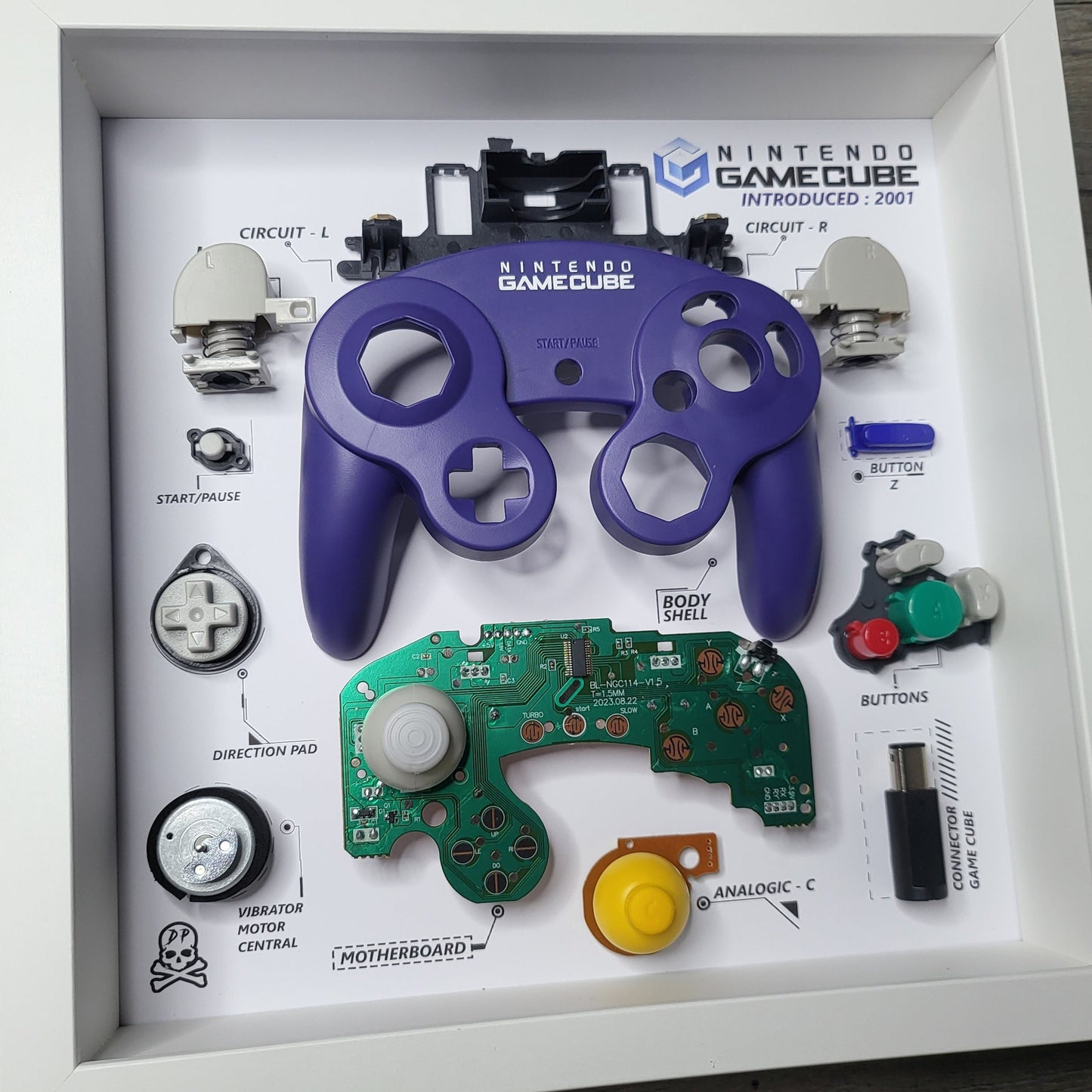 Shadow Box 10x10 with wood frame and polycarbonate glass for wall and Tabletop containing a disassembled controller for Playstation and Nintendo