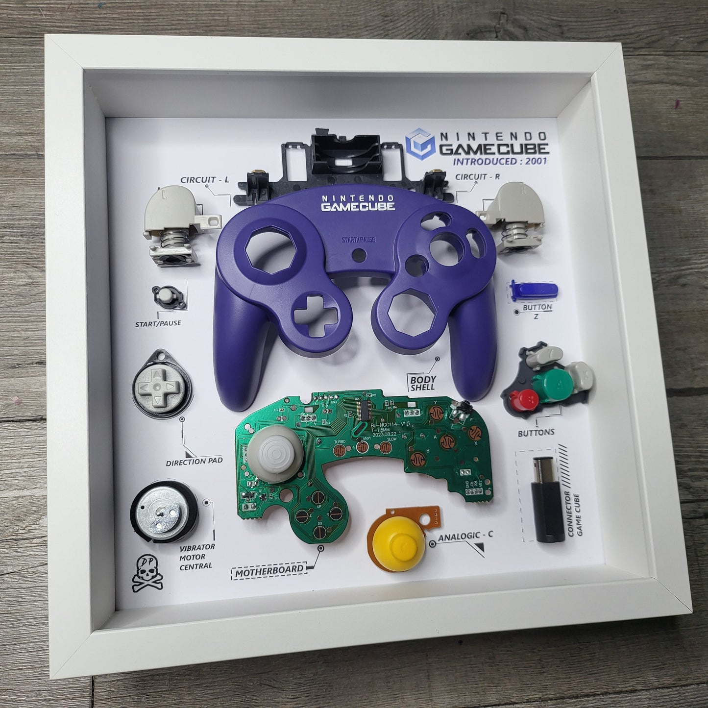 Shadow Box 10x10 with wood frame and polycarbonate glass for wall and Tabletop containing a disassembled controller for Playstation and Nintendo