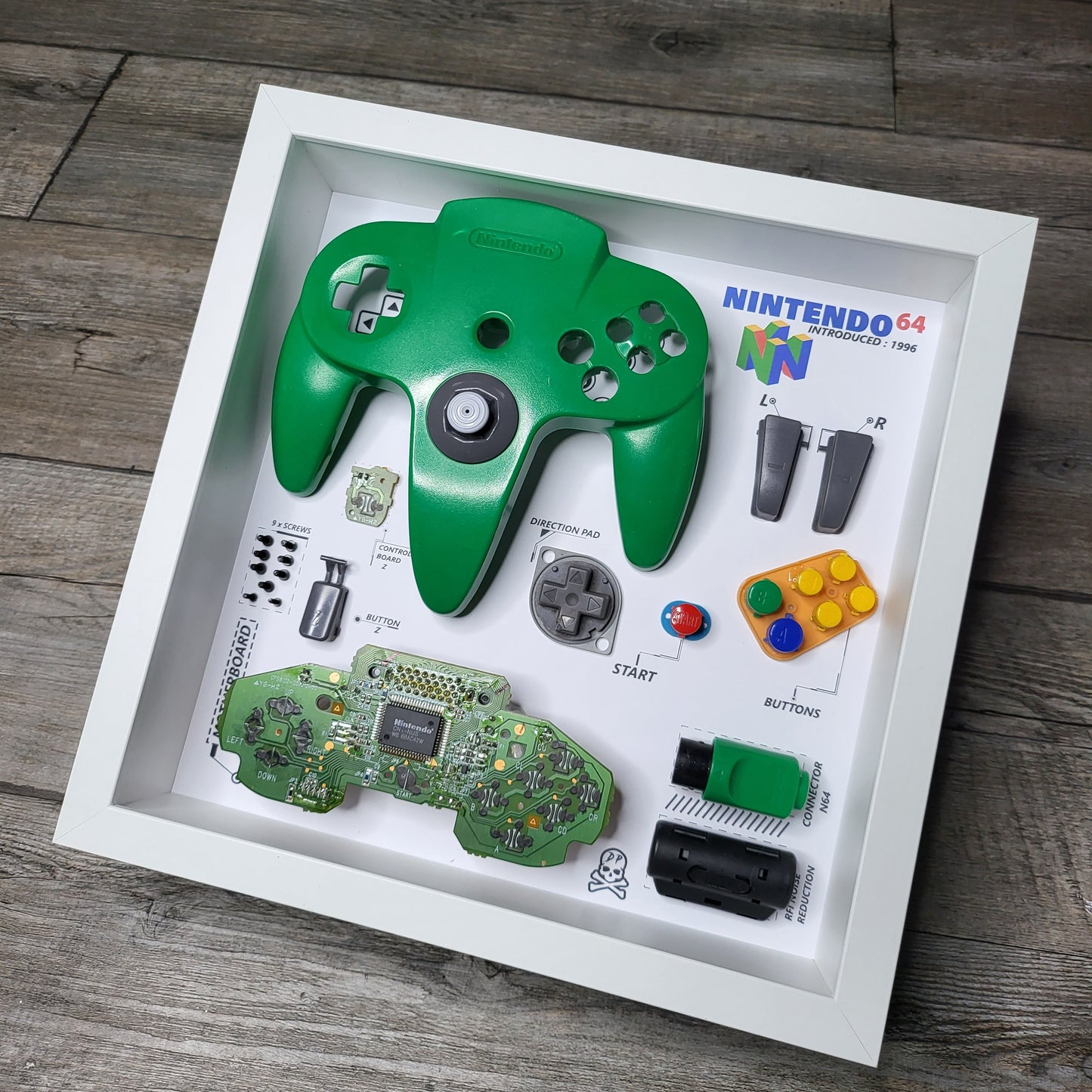 Shadow Box 10x10 with wood frame and polycarbonate glass for wall and Tabletop containing a disassembled controller for Playstation and Nintendo