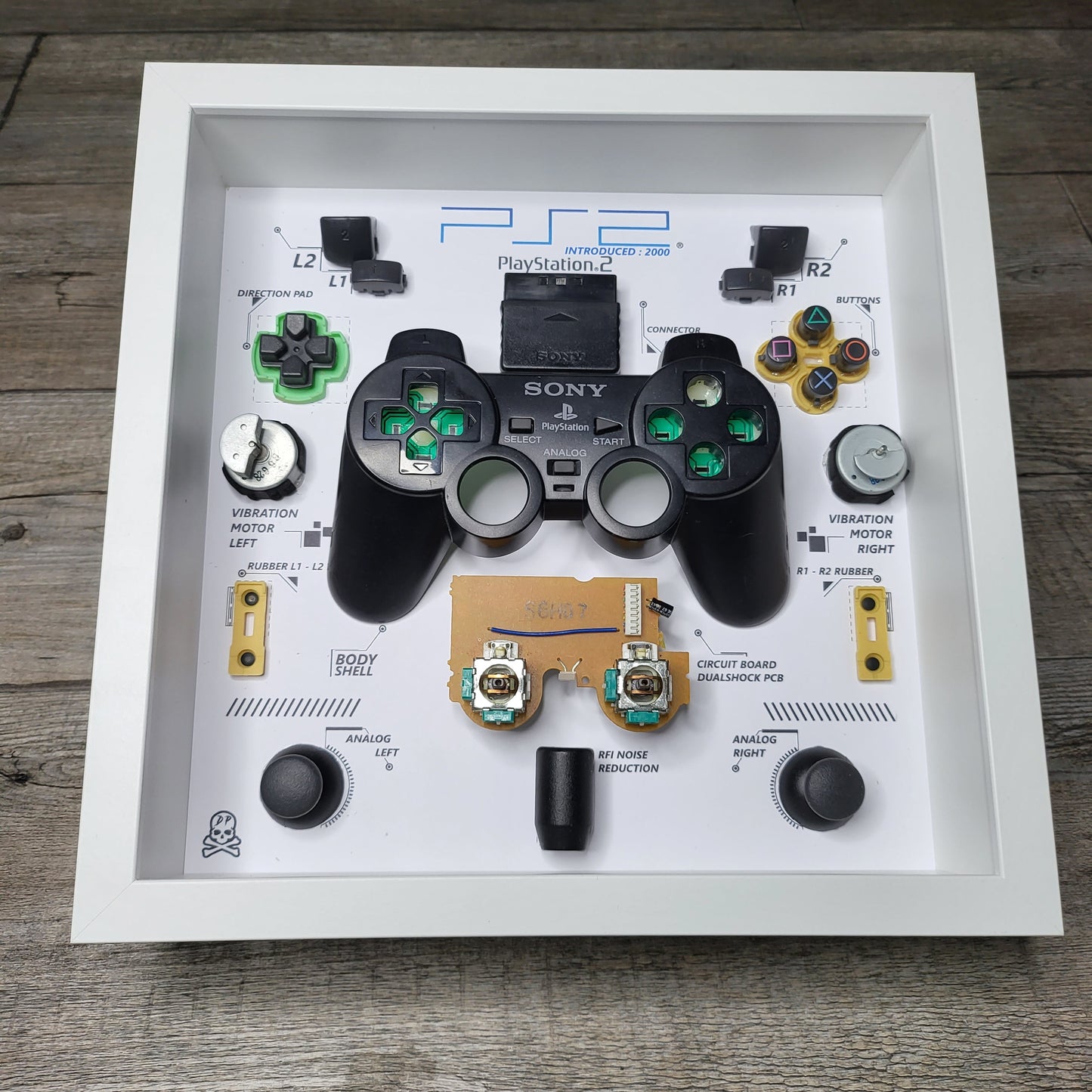 Shadow Box 10x10 with wood frame and polycarbonate glass for wall and Tabletop containing a disassembled controller for Playstation and Nintendo