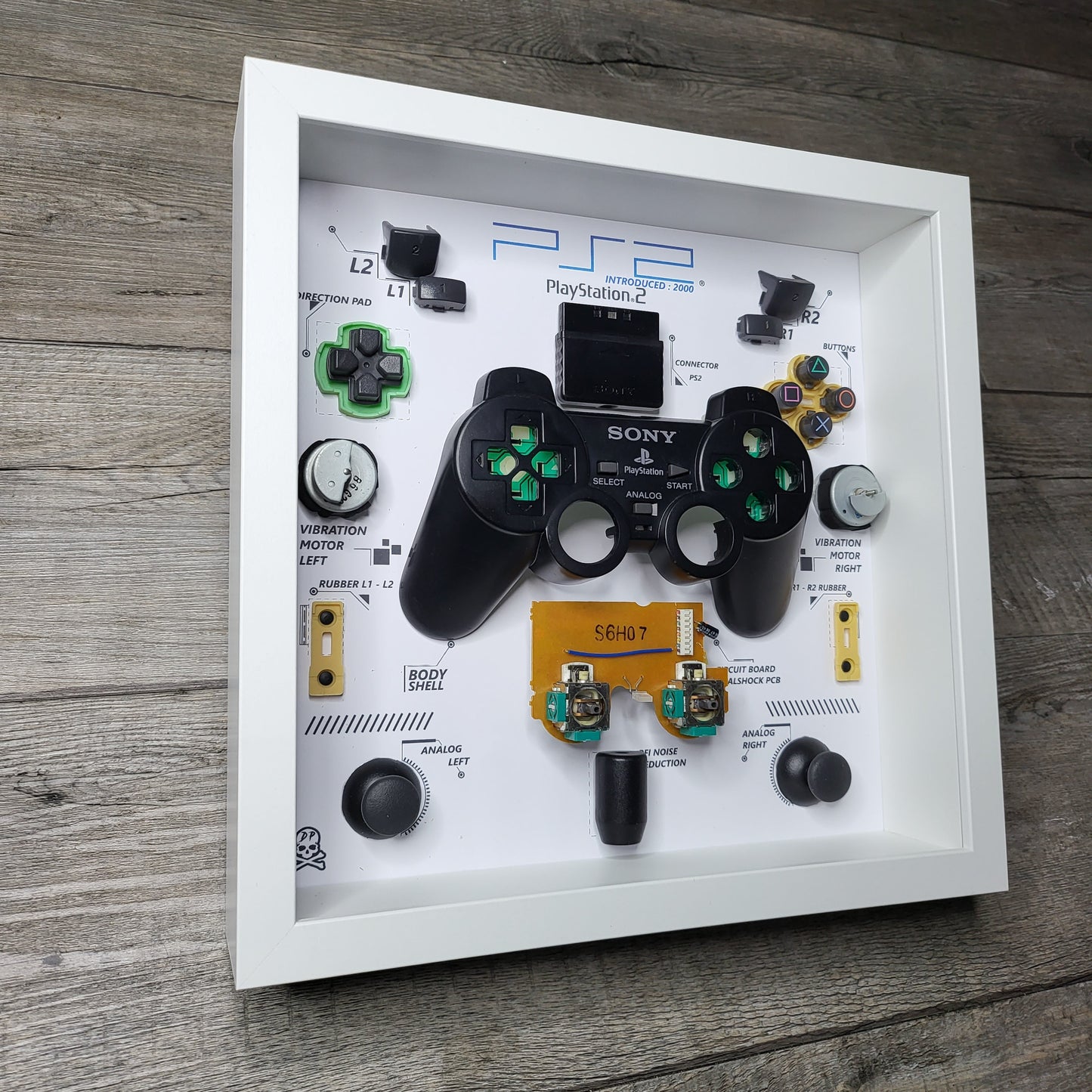 Shadow Box 10x10 with wood frame and polycarbonate glass for wall and Tabletop containing a disassembled controller for Playstation and Nintendo